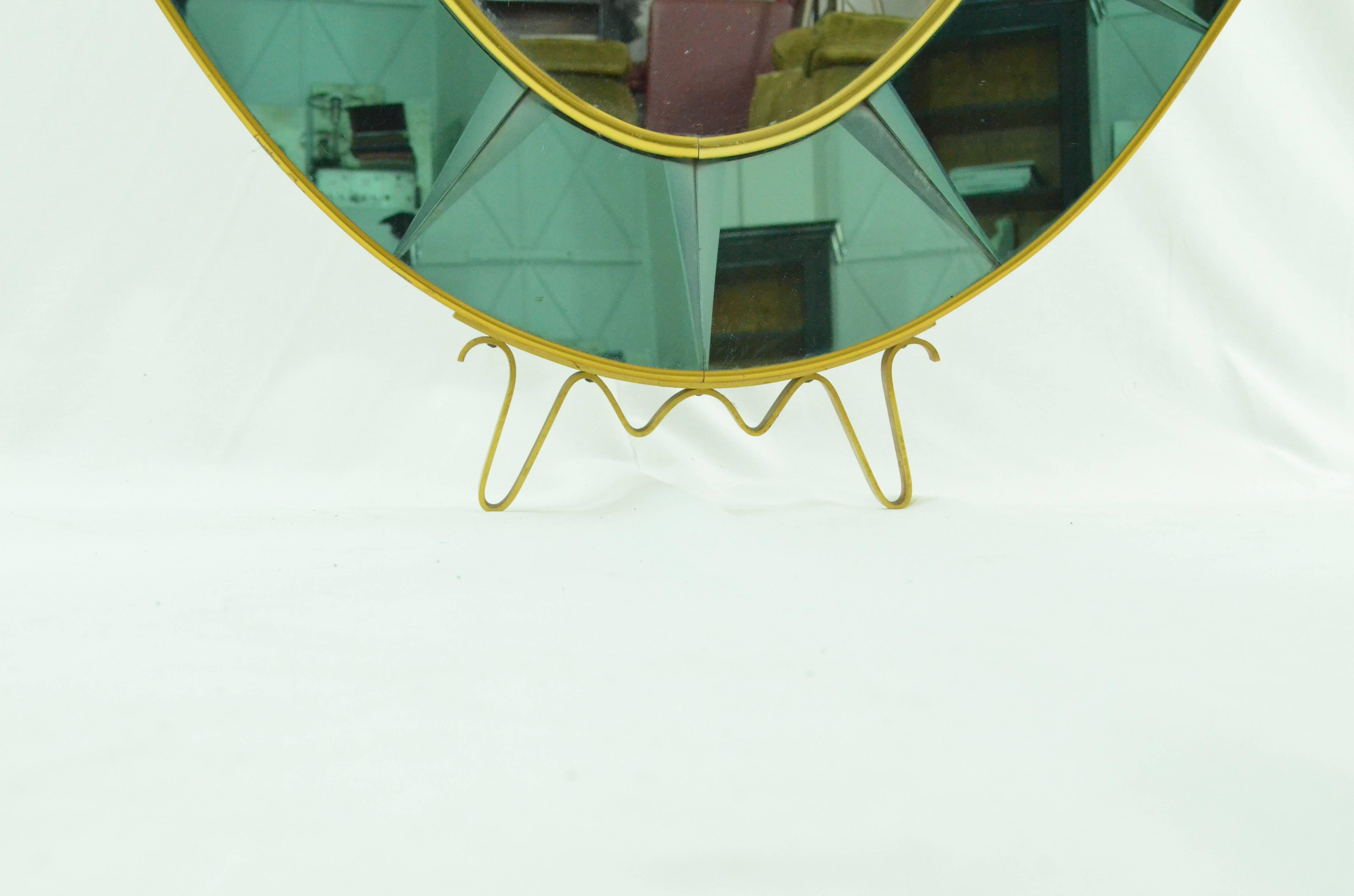 Famous oval grinding and coloured mirror by crystal Arte. The oval green edge is composed by different grinding mirror sections lined with brass. It comes with original brass pedestal so it can stand. It is in perfect conditions.
 