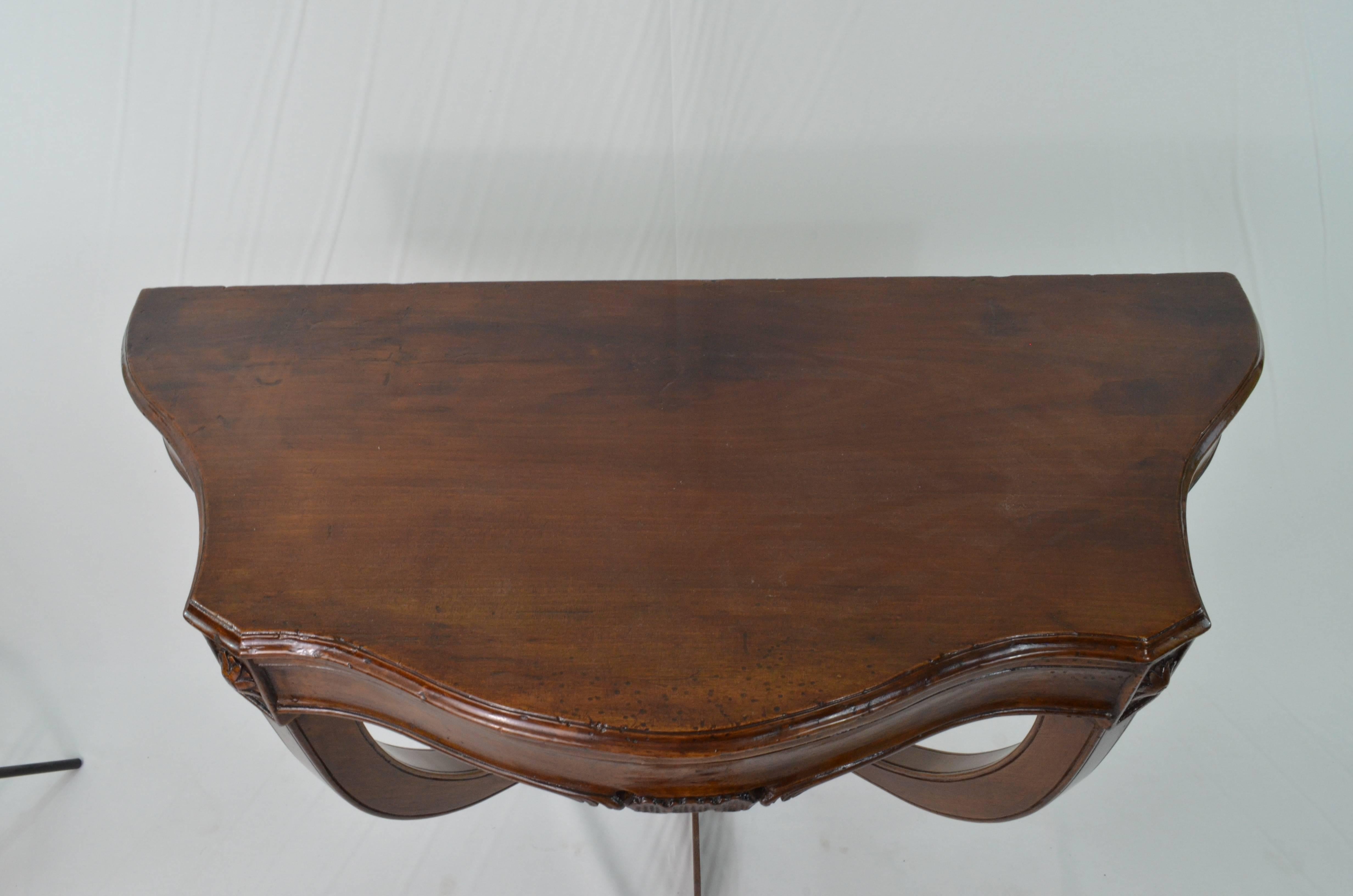 Walnut wood console tables to be hanged, from Italy (Veneto Region because of the typical engravings flower shaped detail). Period Louis XV, 18th century. They are in perfect conditions and underwent only a normal conservative restoration (waxing