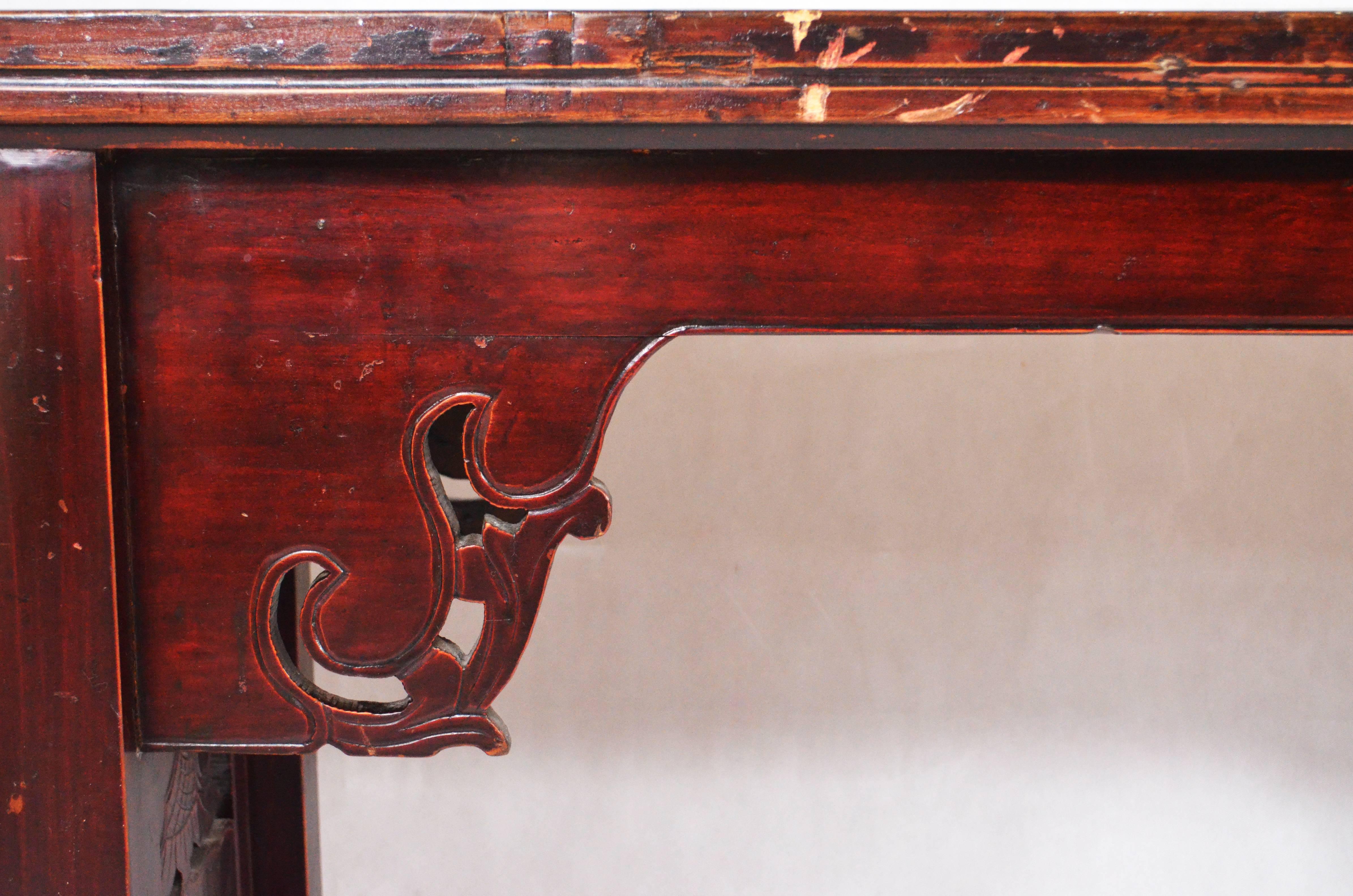 Chinese homu wood console table, from mid-19th century.
It features his original color, a classic Chinese lacquer in dark red that is slightly disappeared on the top and on the legs, showing the natural grain of homu.
The table is finished and
