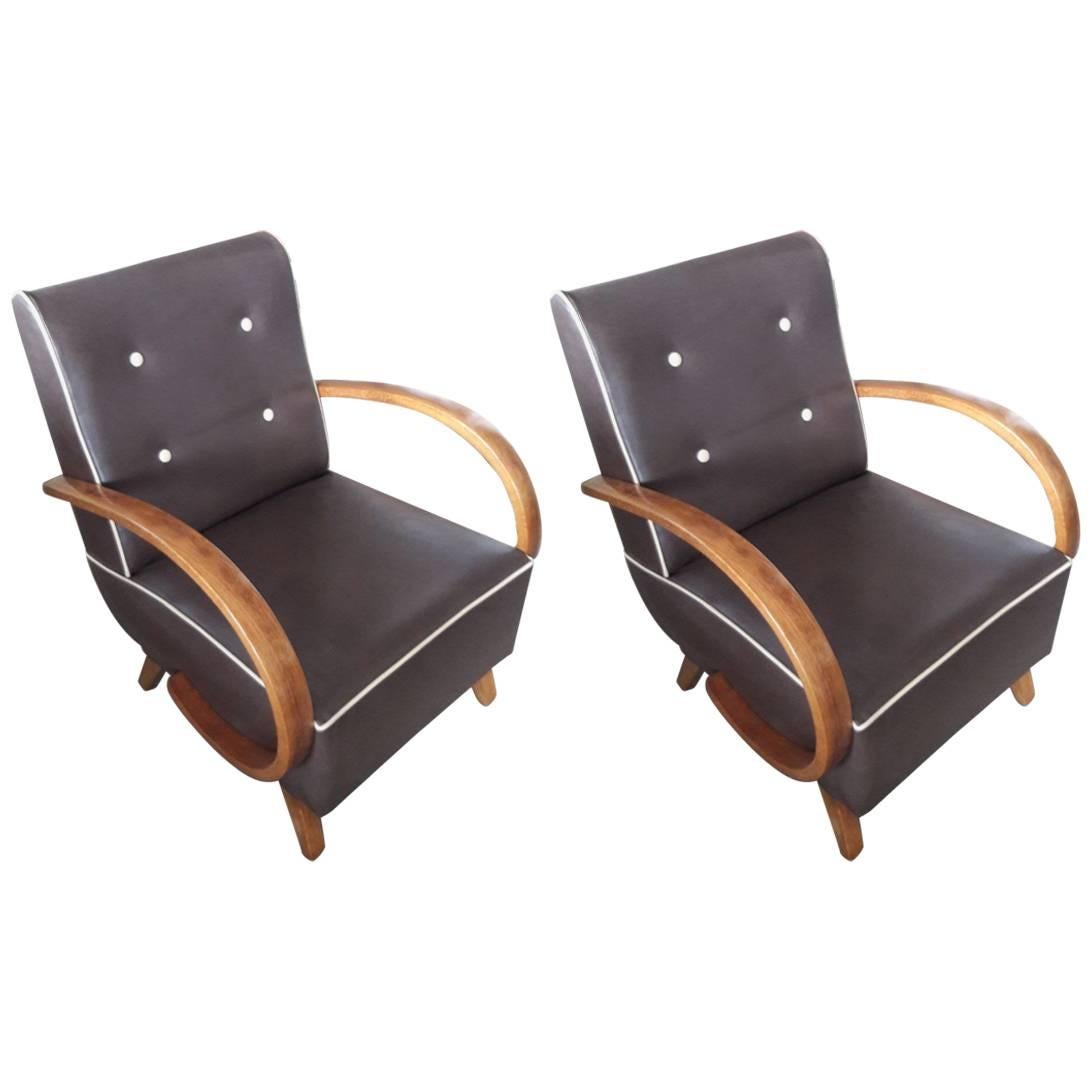 Pair of brown leather reupholstered armchairs, from Art Deco period. Cream details and buttons to have a light capittonne effect on the backrest. Walnut wood armrest restored in a conservative way with wax finishing.
These armchairs come from 1930s