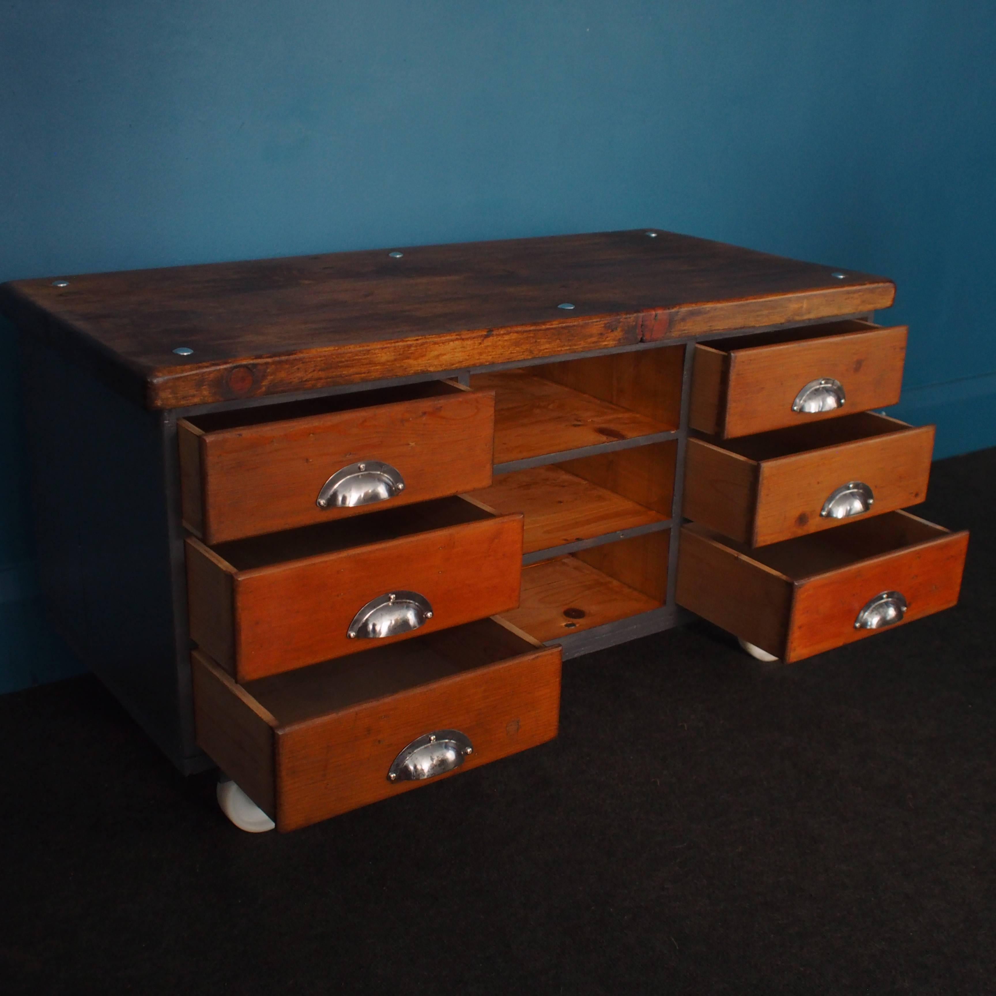 Topped with deep sections of reclaimed timber planks and set on heavy-duty casters, this extremely handsome vintage piece has six dovetail-jointed drawers, each fitted with a steel cup handle and three open shelves, providing ample and versatile
