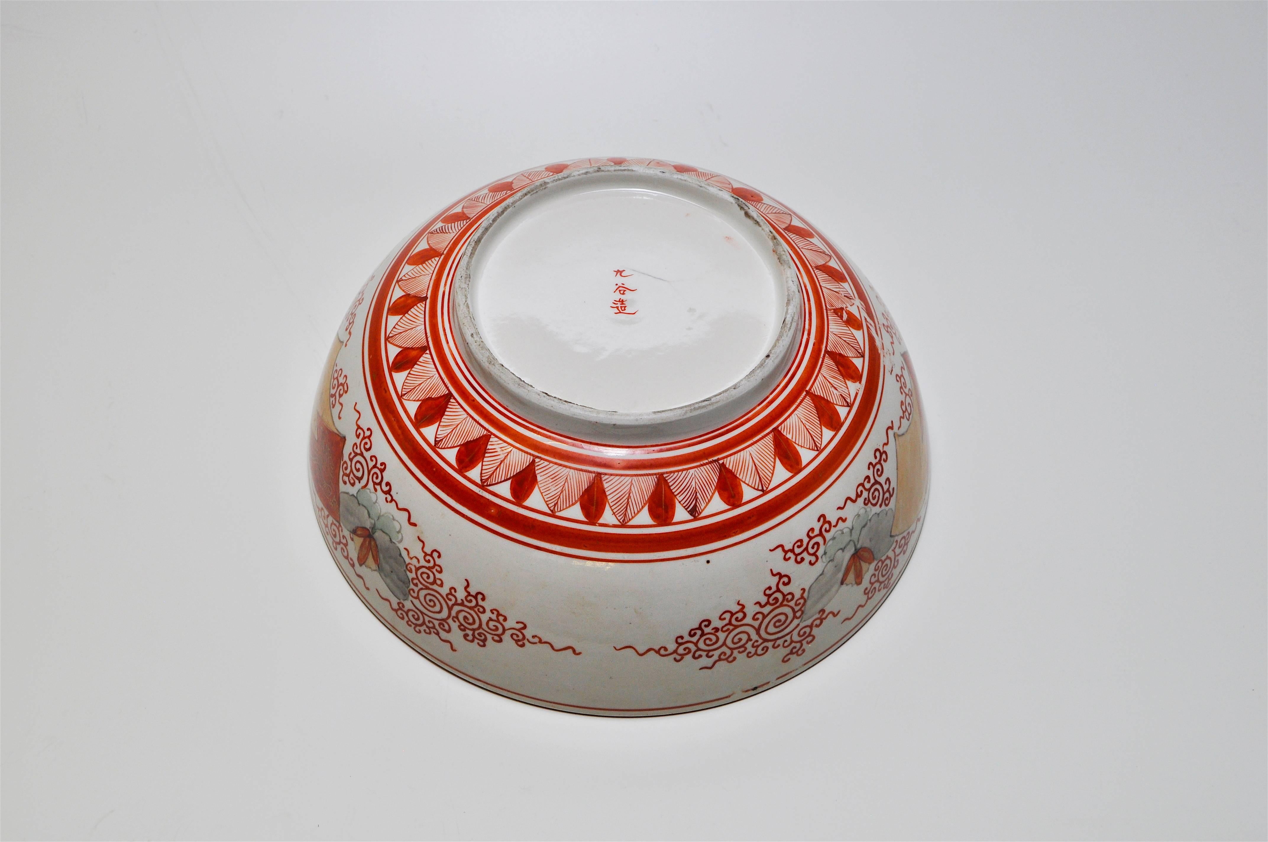 A stunning decorative Japanese bowl in rich autumnal colours of red, orange, rust, black and highlighted in gold. The highly detailed and stylised pattern centralises on a pictorial oriental themed scene most likely from Japanese fables in the base.