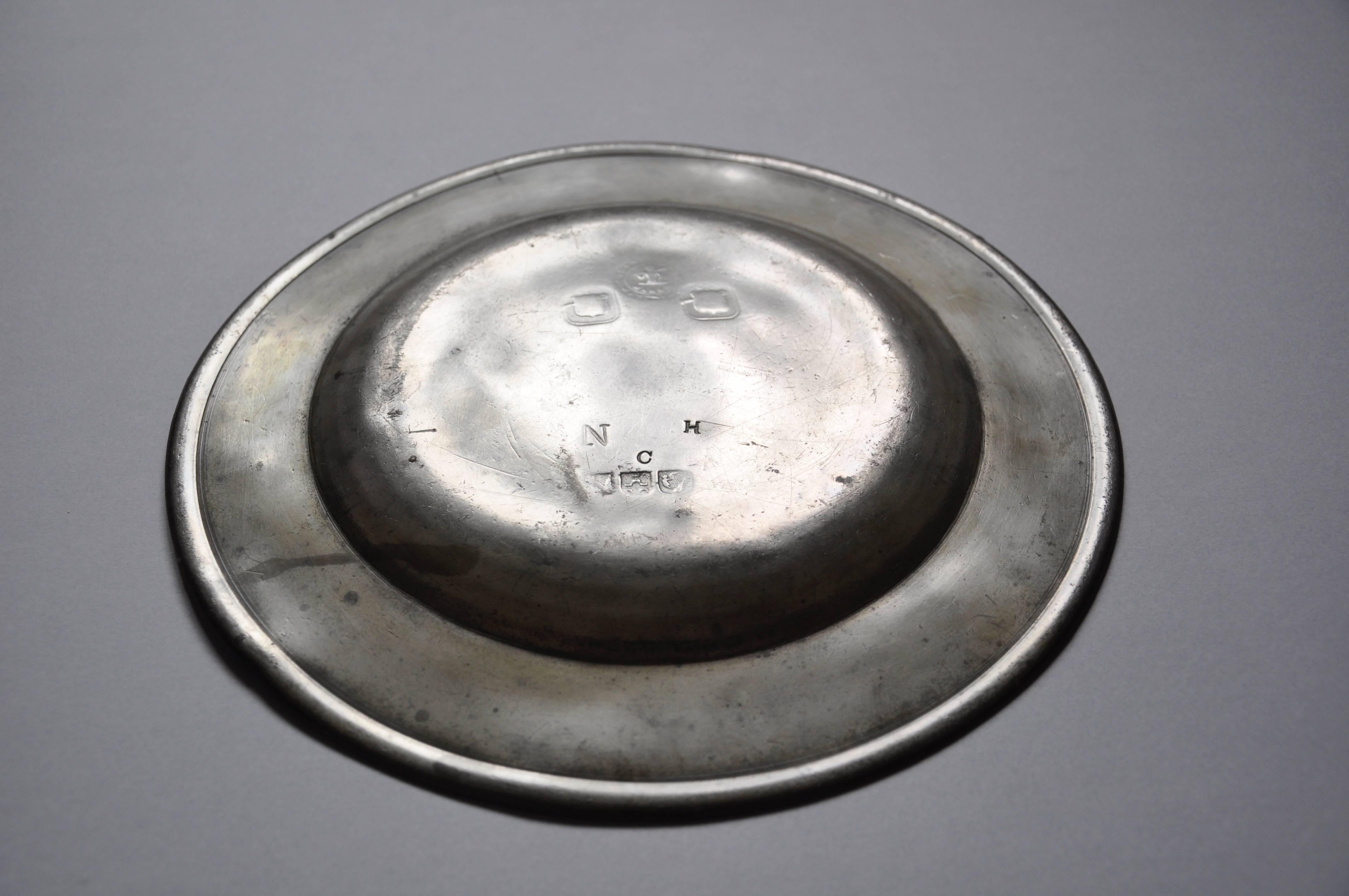 A fine example of an Irish antique, a functional metal plate made by Charles Clarke of Waterford who worked from about 1788-1810. Plain normal-width rim with incised inner single circle reeding. On the back the hallmarks can be made out as the