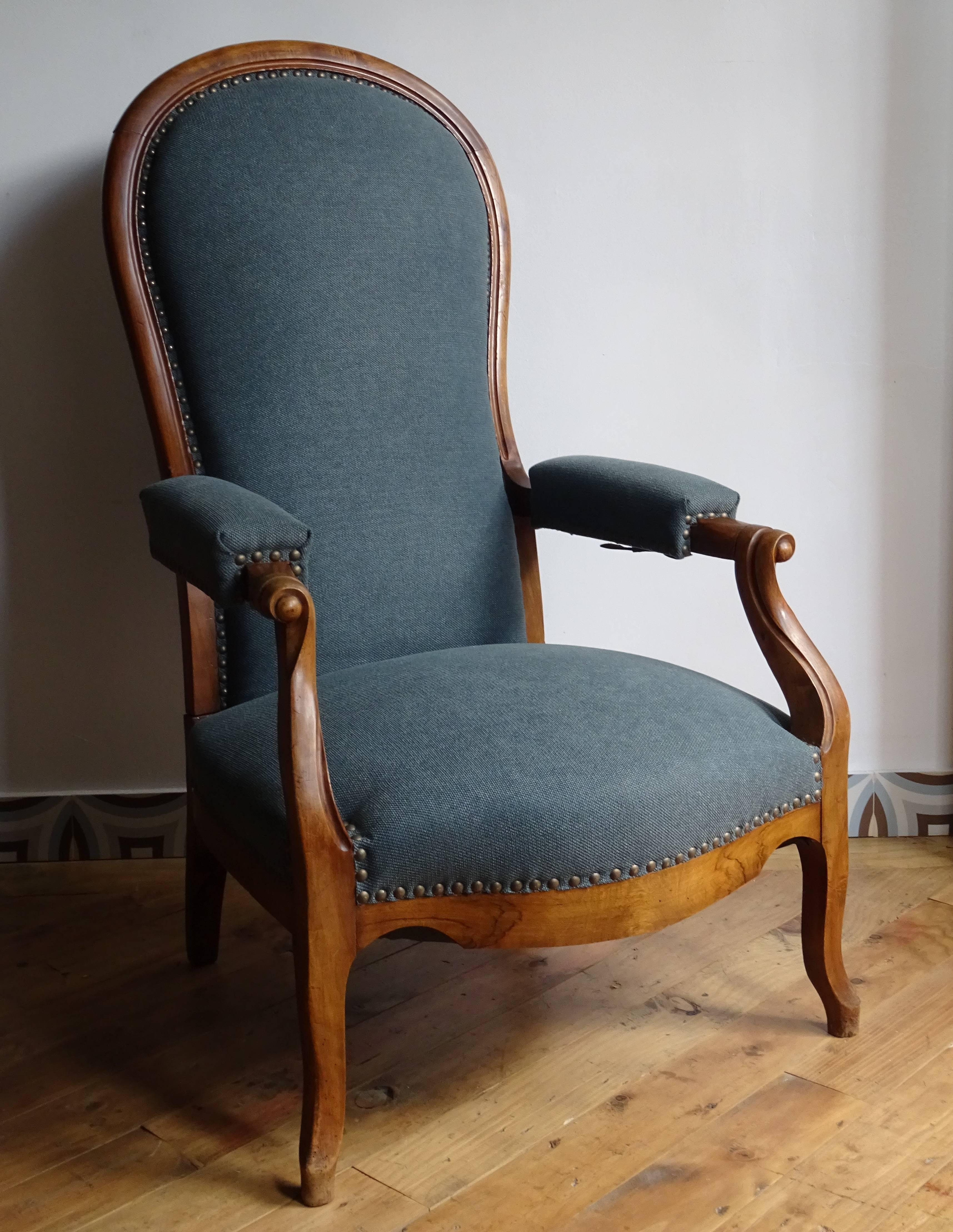 Walnut Voltaire armchair with new upholstery in gray-blue tones. The backrest can be tilted back with a lever system under the armrests. Ulphostery renewed.

 