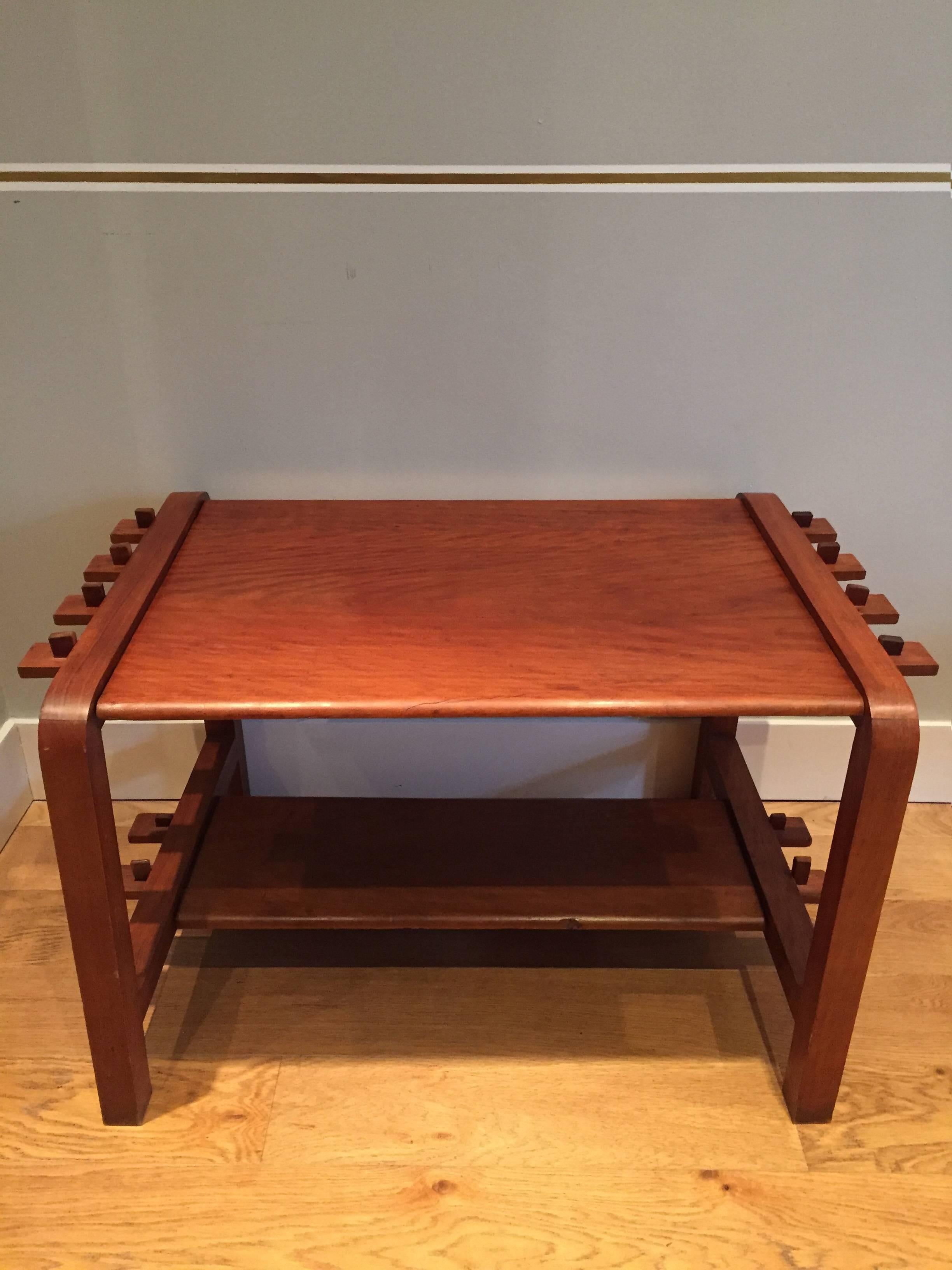A most unusual modernist cherrywood coffee table, entirely dismantable with a system of pegs, the two D shaped side structures supporting the top and a lower shelf,
France, circa 1940.
Measures: 90 cm long by 58 cm wide by 55 cm high.