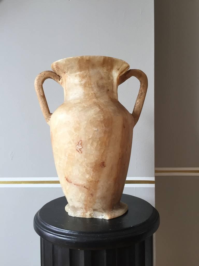A carved alabaster urn shaped vase, with twin handles, 'à l'antique', in the ancient Egyptian style.
Grand Tour item from the 1920s.
Measures: 26 cm high.