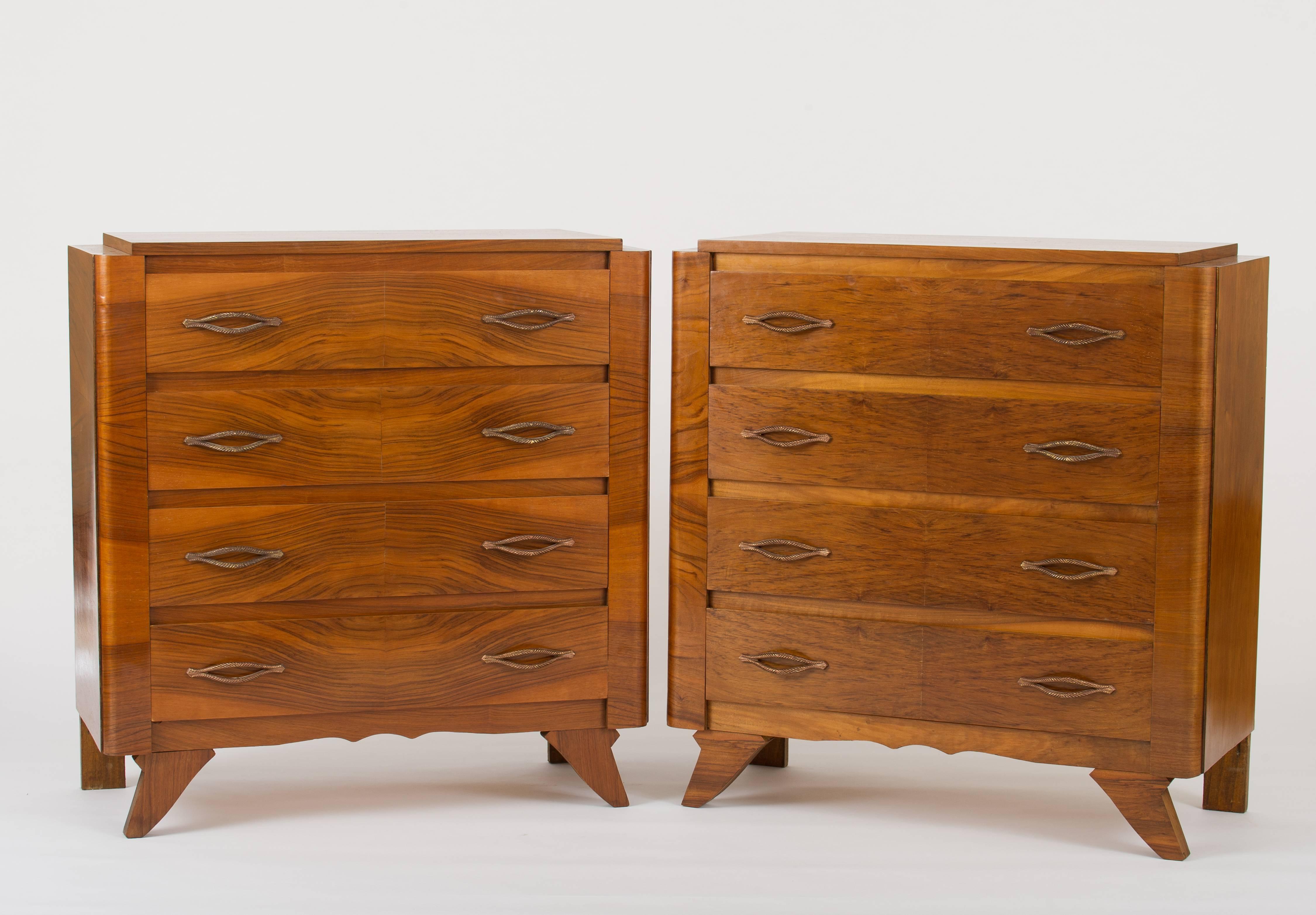 A pair of walnut veneered four-drawer commodes, of interesting construction and with most unusual stylised cordeliere brass handles
France, late 1940s.