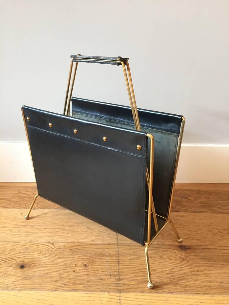 A brass and black leather magazine holder,
France, circa 1955.