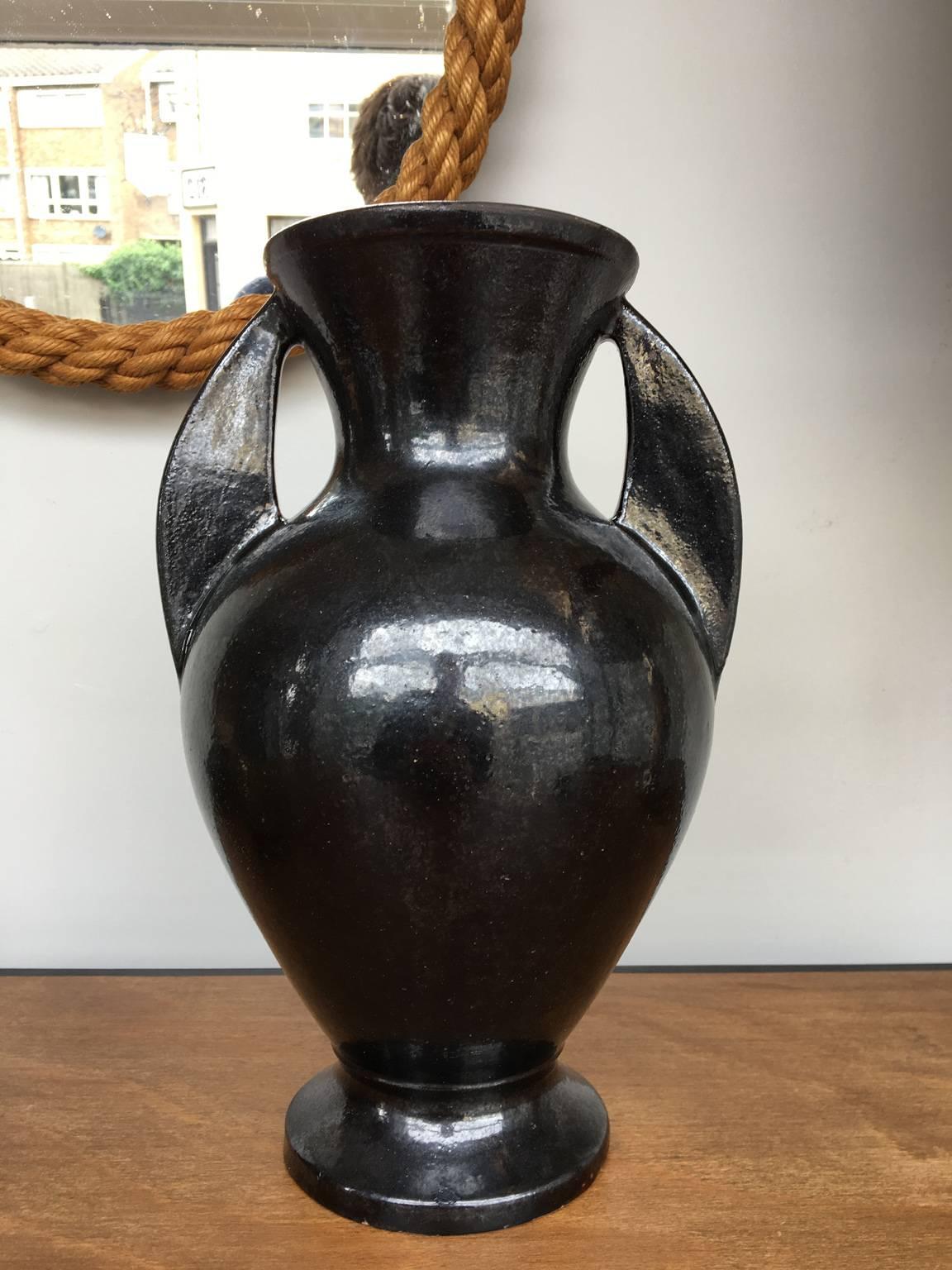 A large black ceramic urn shaped vase, with twin handles
France, circa 1950.