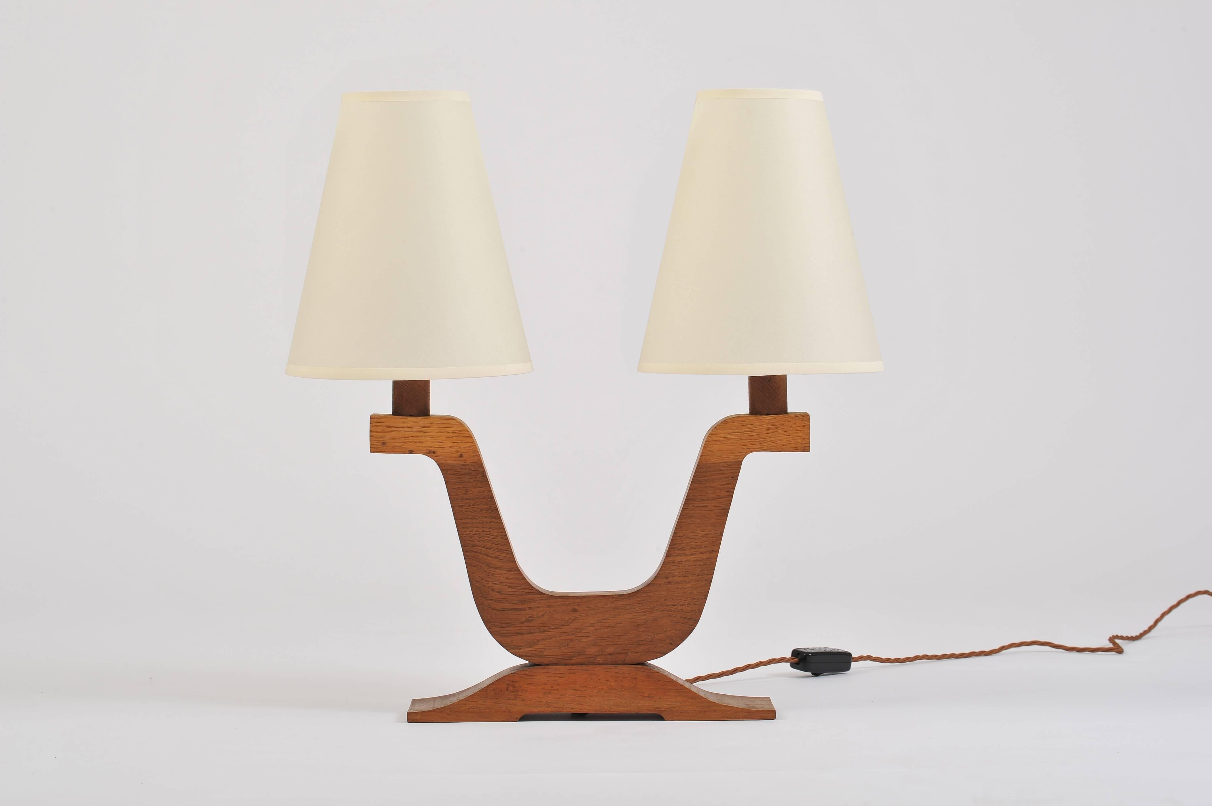 A pair of Art Deco oak two armed table lamps
with bespoke tapered card shades
France, circa 1930.