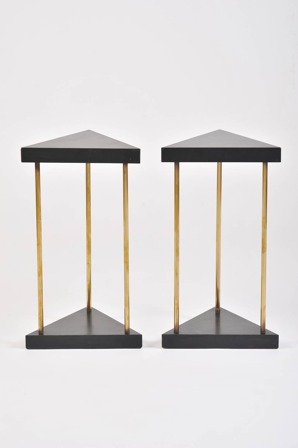 A pair of brass and black melaminate triangular side tables
France, circa 1950.