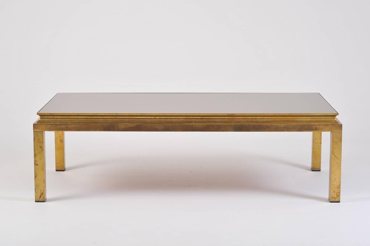 A brass and bronze mirror top rectangular coffee table, in its original patina
France, circa 1970.