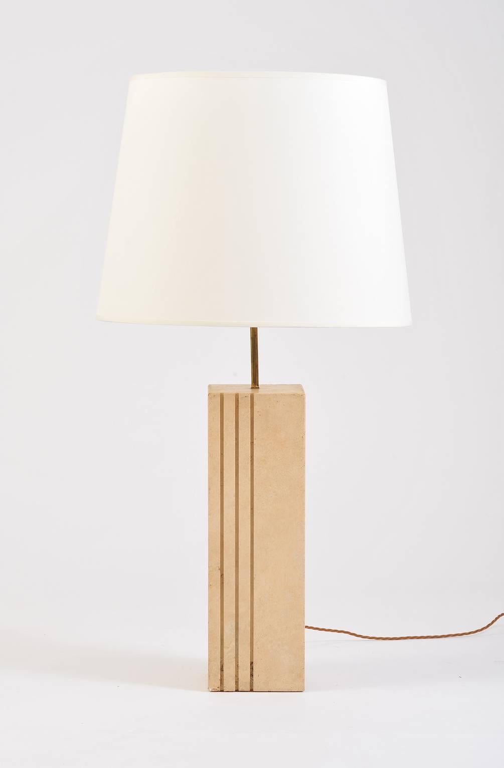 A large solid travertine lamp, the square column base supporting a bespoke ivory fabric tapered shade
Italy, circa 1970.