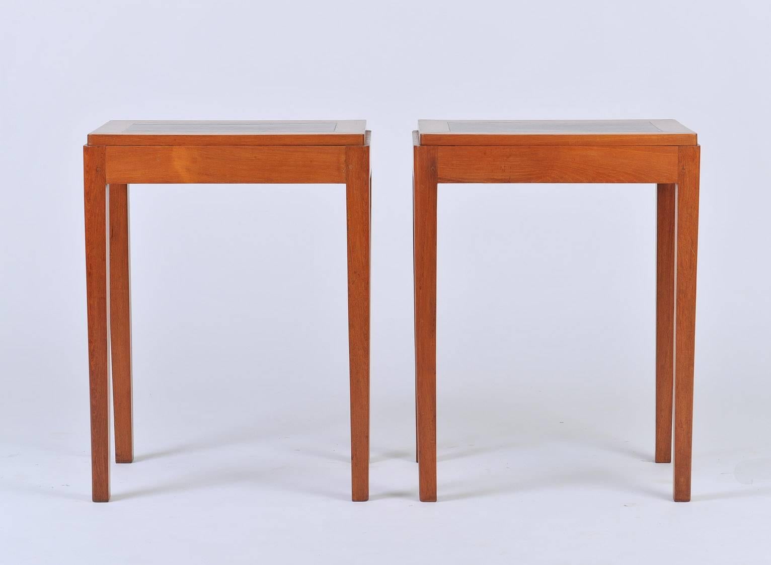 A pair of Art Deco teak and mahogany side tables, the two tome tops with stepped moldings and elegant rounded edges,
France, circa 1930.