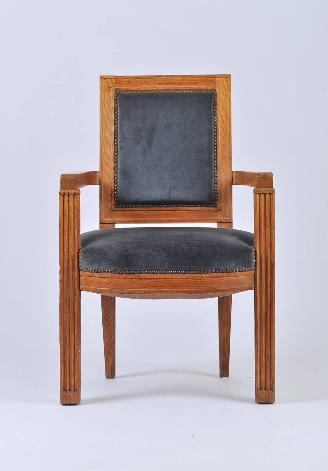 A carved oak armchair by Charles Dudouyt (1885-1946) 
Studded and upholstered with a blue mohair velvet
France, circa 1940.