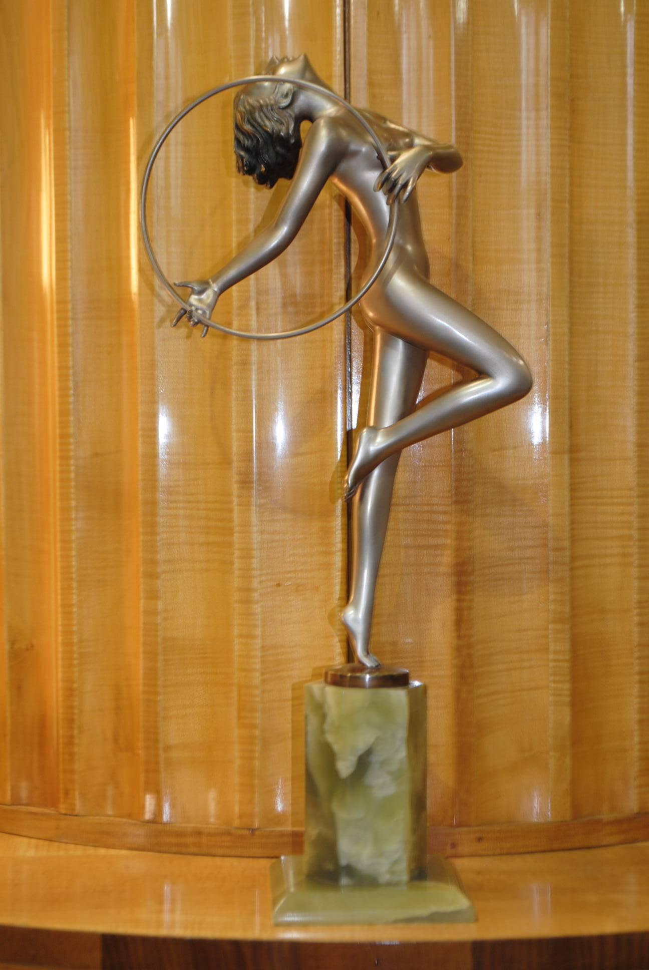 This magnificent piece by Josef Lorenzl ‘The Hoop Dancer’ is an original Art Deco silver patinated bronze figure on faceted onyx base, circa 1925. The naked lady is poised upon one leg with her head reclining as she dances with the hoop. A stunning