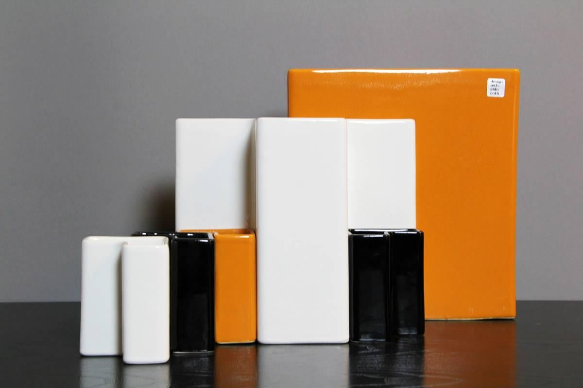 This set of desk containers was designed by Italian architect Aldo Cotti for Tronconi during the 1970s. The pieces are made from ceramic and glazed in black, orange and white. This set features two big containers, measuring 21cm (white) and 26cm