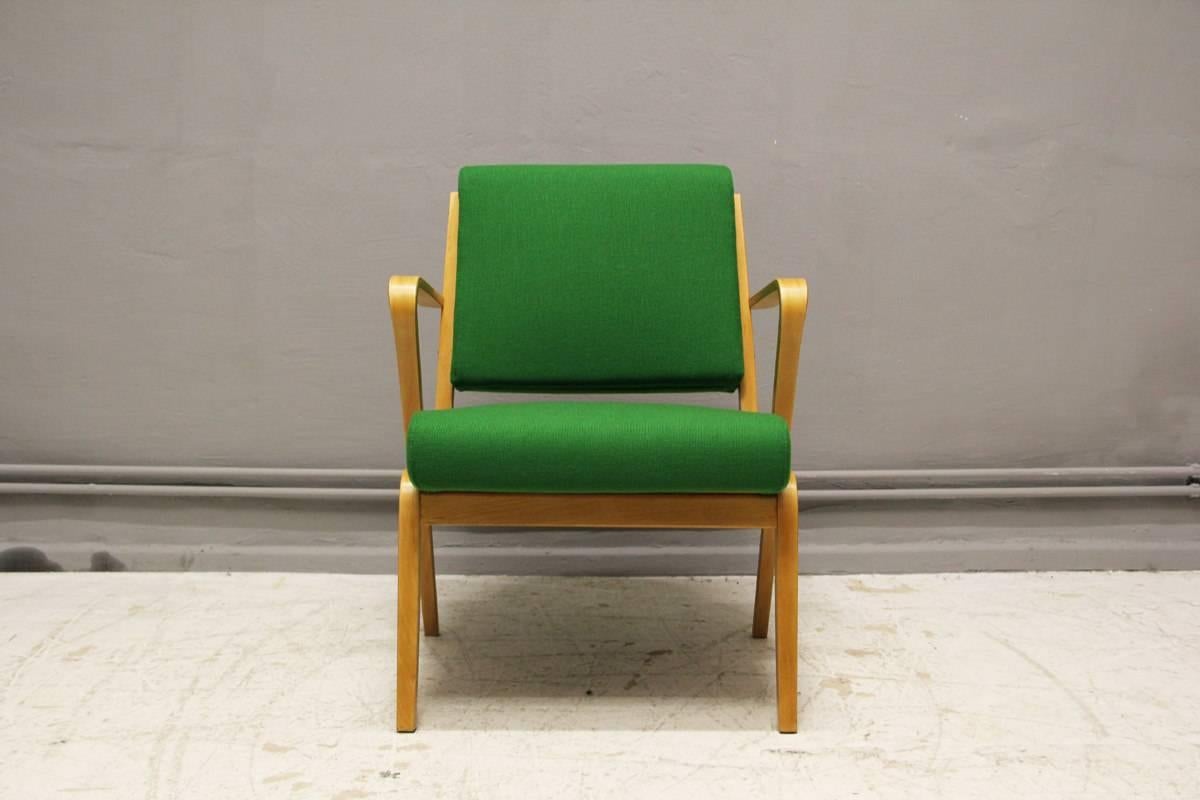 This armchair, model 53693, was designed in 1957 by Bauhaus student Selman Selmanagic and manufactured by VEB Deutsche Werkstätten Hellerau. It features laminated beechwood and apple green fabric upholstery. The chair is completely restored and in
