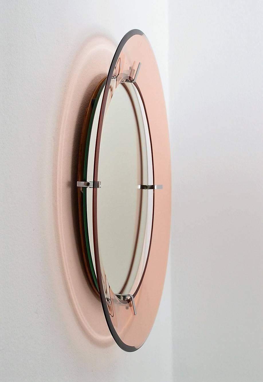 Beautiful round wall mirror with light pink (rose) glass frame, hold with chrome-plated holders.
The mirror is typical for Italian manufacturing from the 1970s by Cristal Arte.
Very feminine and elegant.
The diameter of the mirrored glass itself