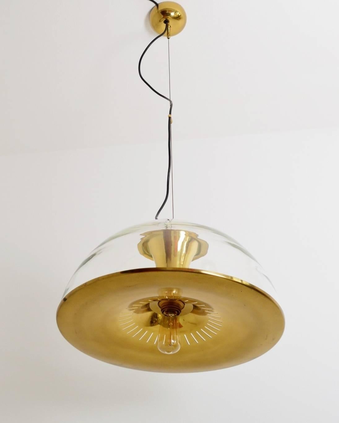 Beautiful particular glass dome pendant lamp with shiny brass parts with fantastic dark patina.
Hollywood Regency Style
The lower part of the lamp is made of full brass with thin slots, which are producing nice light effects.
The glass dome is