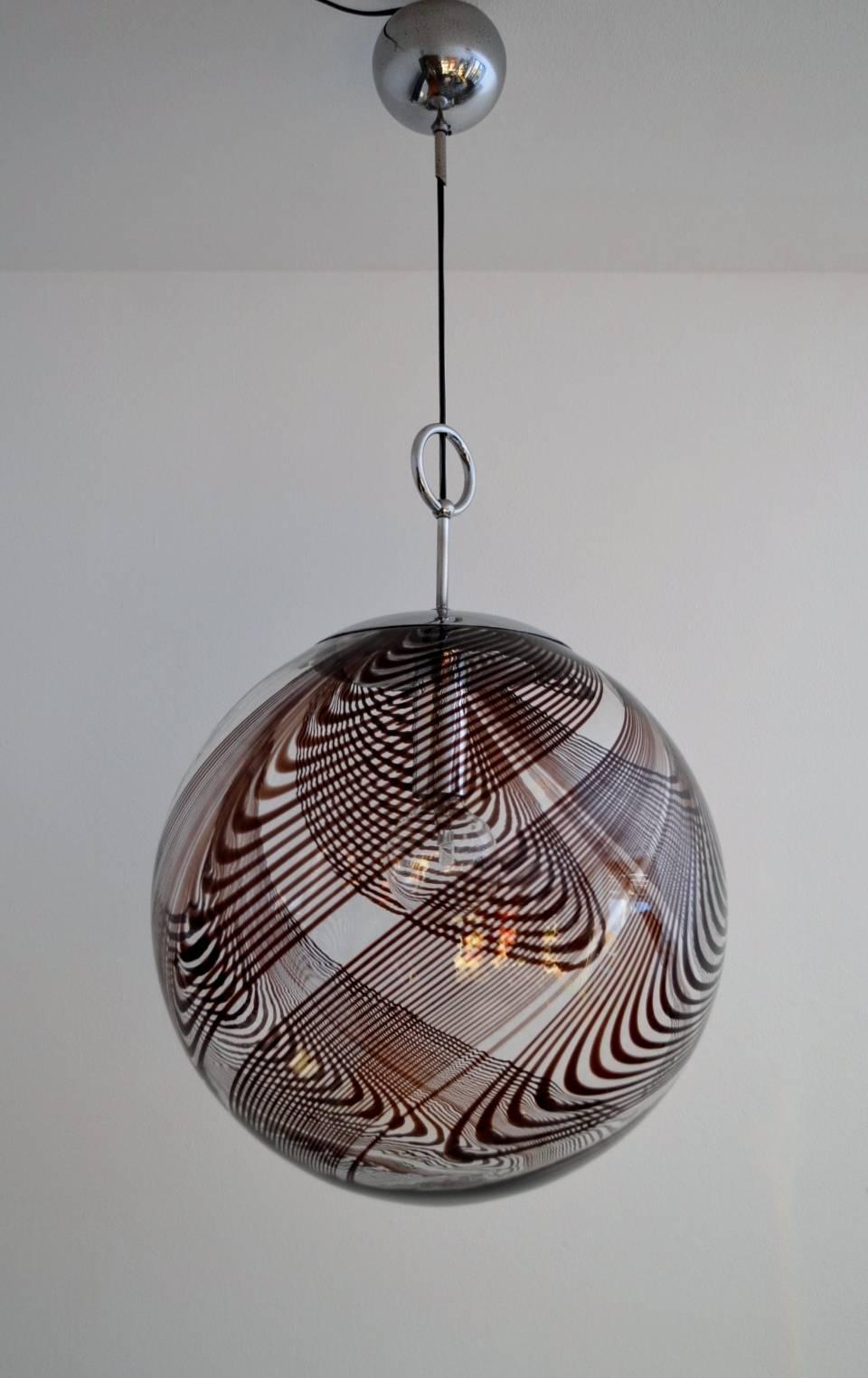 Beautiful huge glass globe with chocolate colored dark swirled smaller and larger lines around the globe, designed by Lino Tagliapietra and manufactured from La Murrina, 1960s.
Amazing artistic work, which leaves a beautiful pattern to the wall when