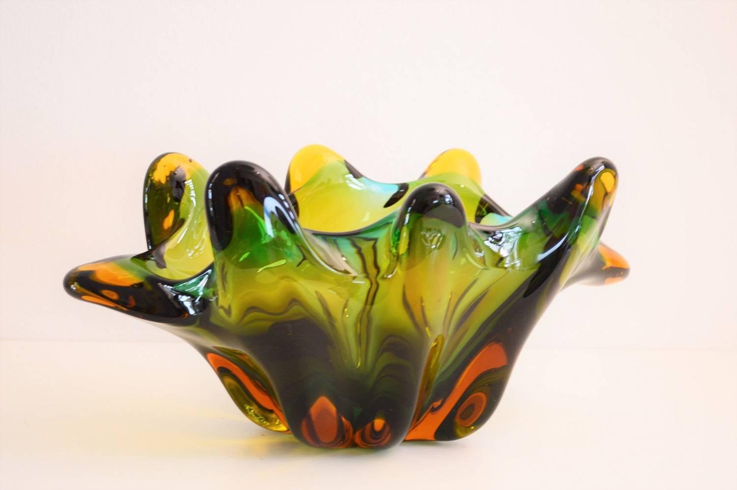 Gorgeous and heavy centerpiece of Murano art glass in green - blue - amber-yellow and brown shiny colors, which differ depending on the light and position.
The bowl is a real piece of art made by master's hand - and in excellent condition.
Made in