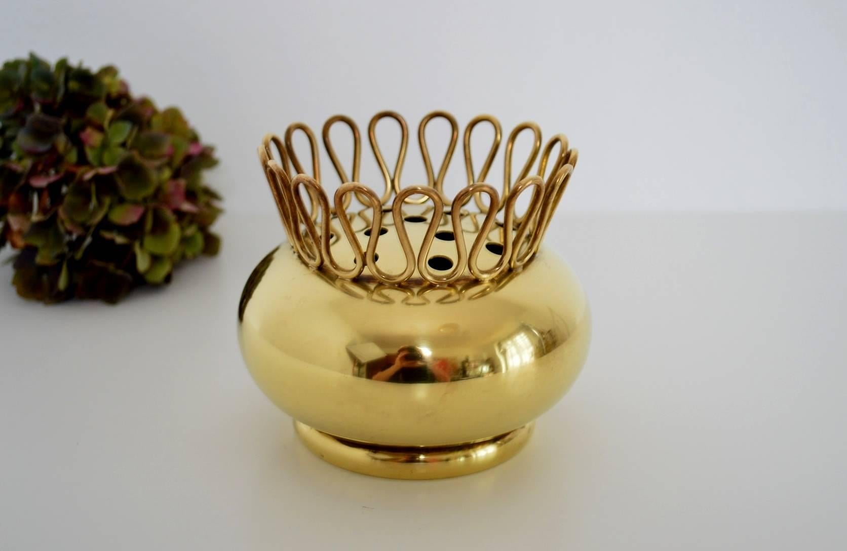 Beautiful small vase made of shiny full brass, Italy in the 1950s typical for the midcentury style.
The vase is provided with a completely handcrafted full brass ornament around the upper part. Within the ornament are many holes, which are made to