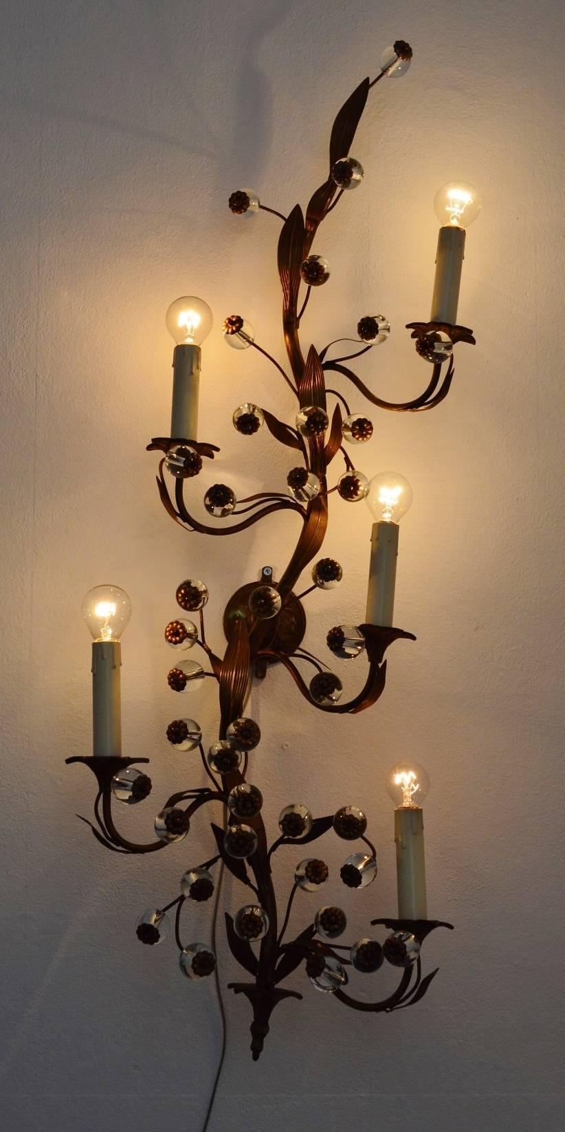 Hugh wall sconce with full brass decorative leafs and flower details on transparent Murano glass balls.
The wall lamp in the shape of a big flower rod with leaves and flowers has five arms with bulb holders for small candelabra bulbs.
Very