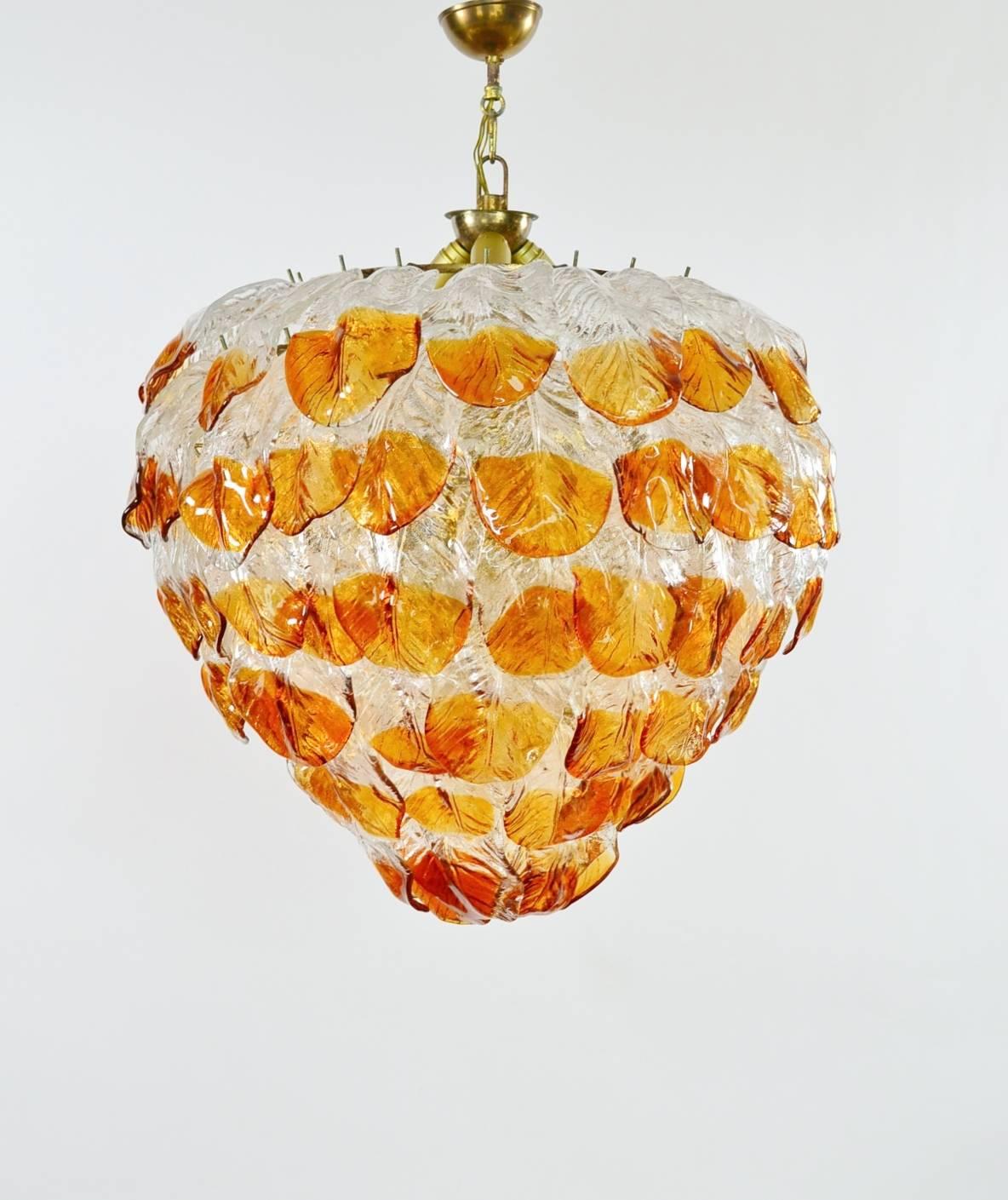 This gigantic Murano glass chandelier was produced in Italy during the 1960s. Due to its quality it has been attributed to Mazzega production.
It is made of a solid iron case with brass finish and keeps exactly 99 big handcrafted leafs made of