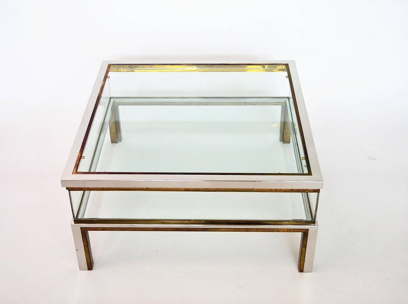 Very elegant 1970s Regency brass and chrome coffee table with internal sliding display case in order to present decorative items, books or magazines.
In the style of Maison Jansen, Made in France, 1970s.

The four transparent internal sides are