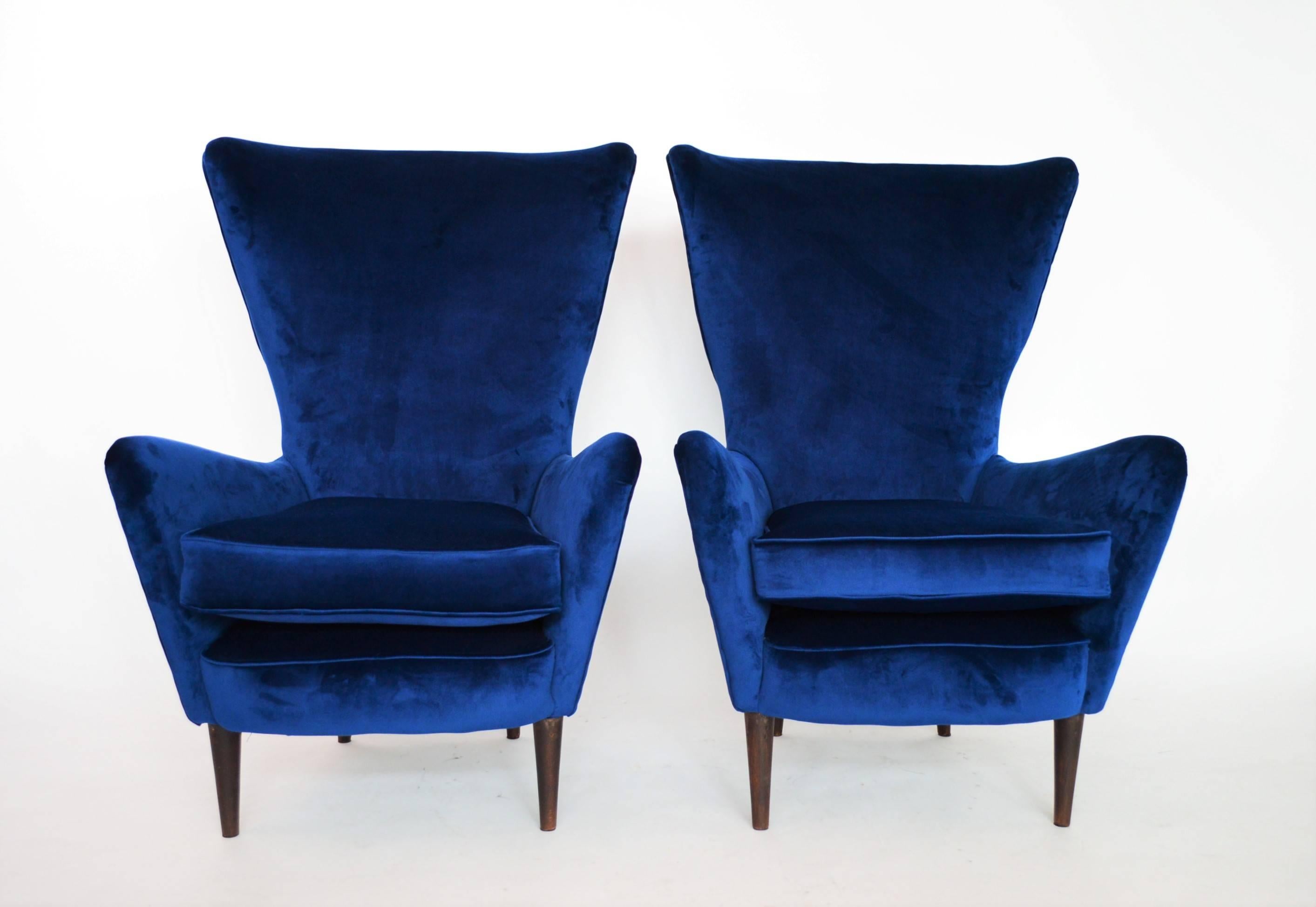 A set of two beautiful and original Italian armchairs or lounge chairs back from the 1950s.
Both chairs have been completely restored and re-upholstered with dark and very soft royal-blue Italian velvet.
Both cushions are new and very soft.
The