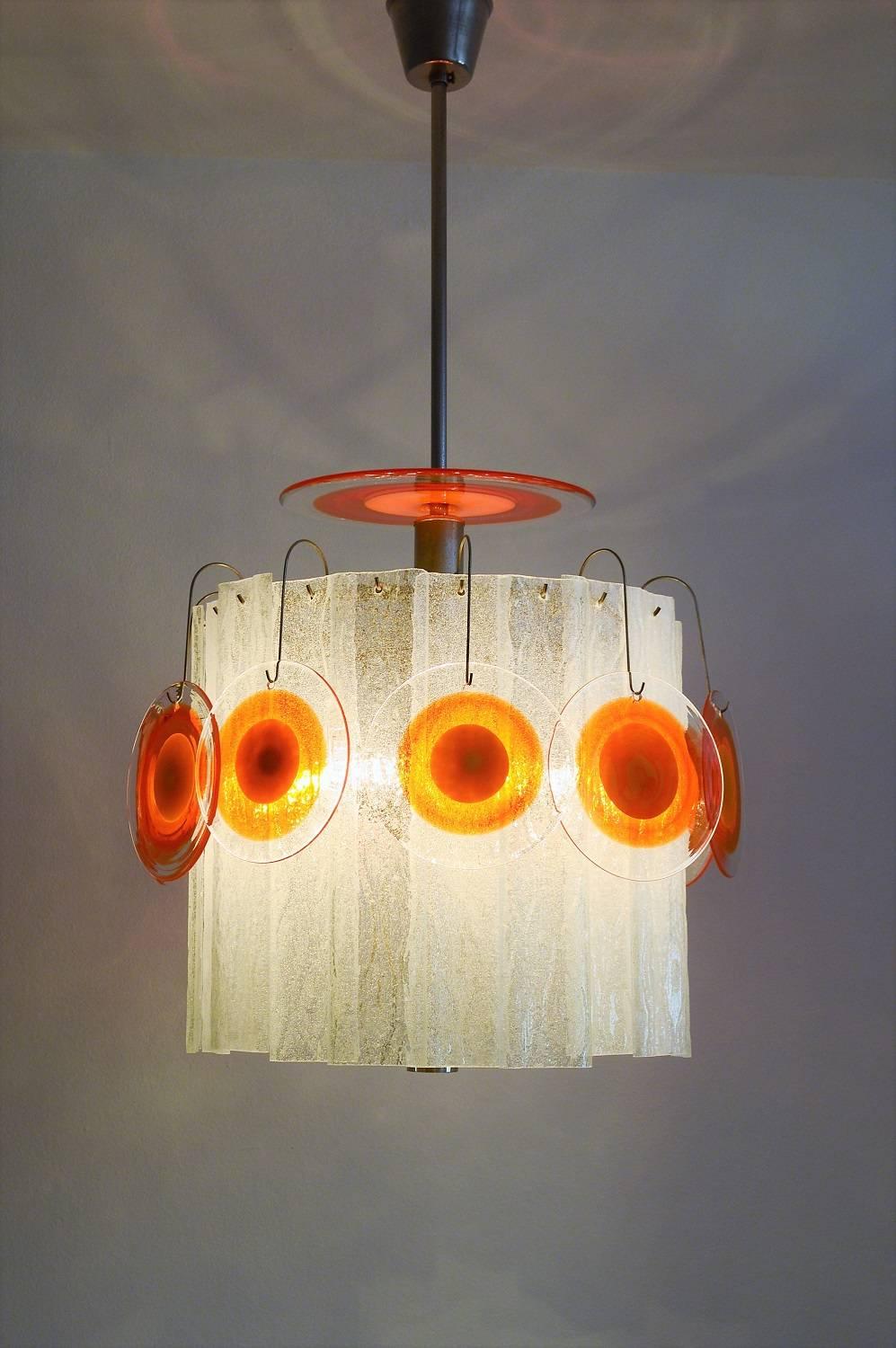 Rare and beautiful Pop Art chandelier in Carlo Nason Style with 20 long milky glasses, ten round small and one big orange swirled glasses.
Made in Italy by Vistosi in the 1970s.
The orange glasses are grouped outside around the circle of white long