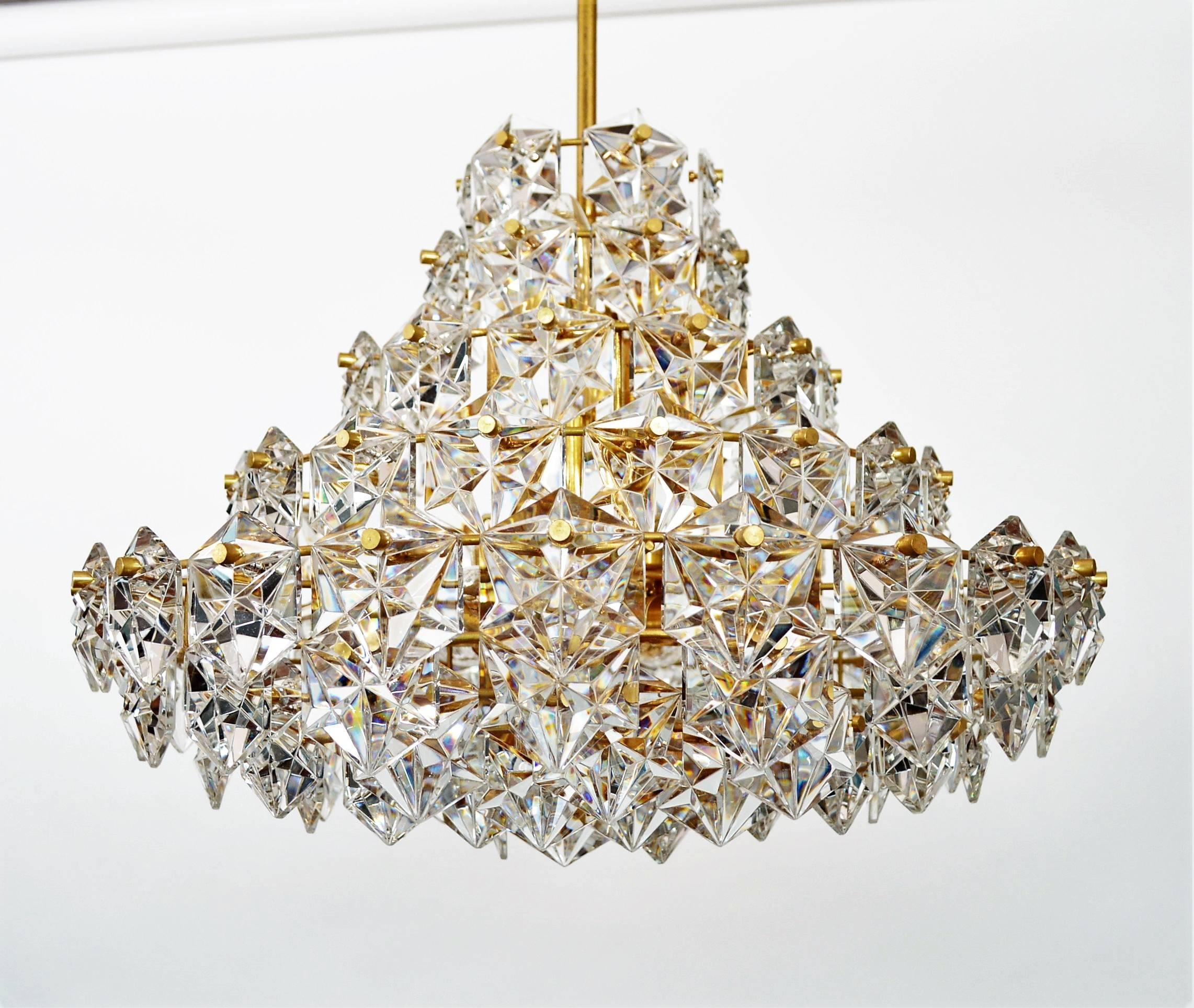 Amazing chandelier with nine-tiers full of shiny crystals and golden metal lamp frame.
Equipped with nine bulb holders for small candelabra E14 bulbs and one below for big Edison E27 standard bulb.
Made during the Hollywood Regency era 1970s in