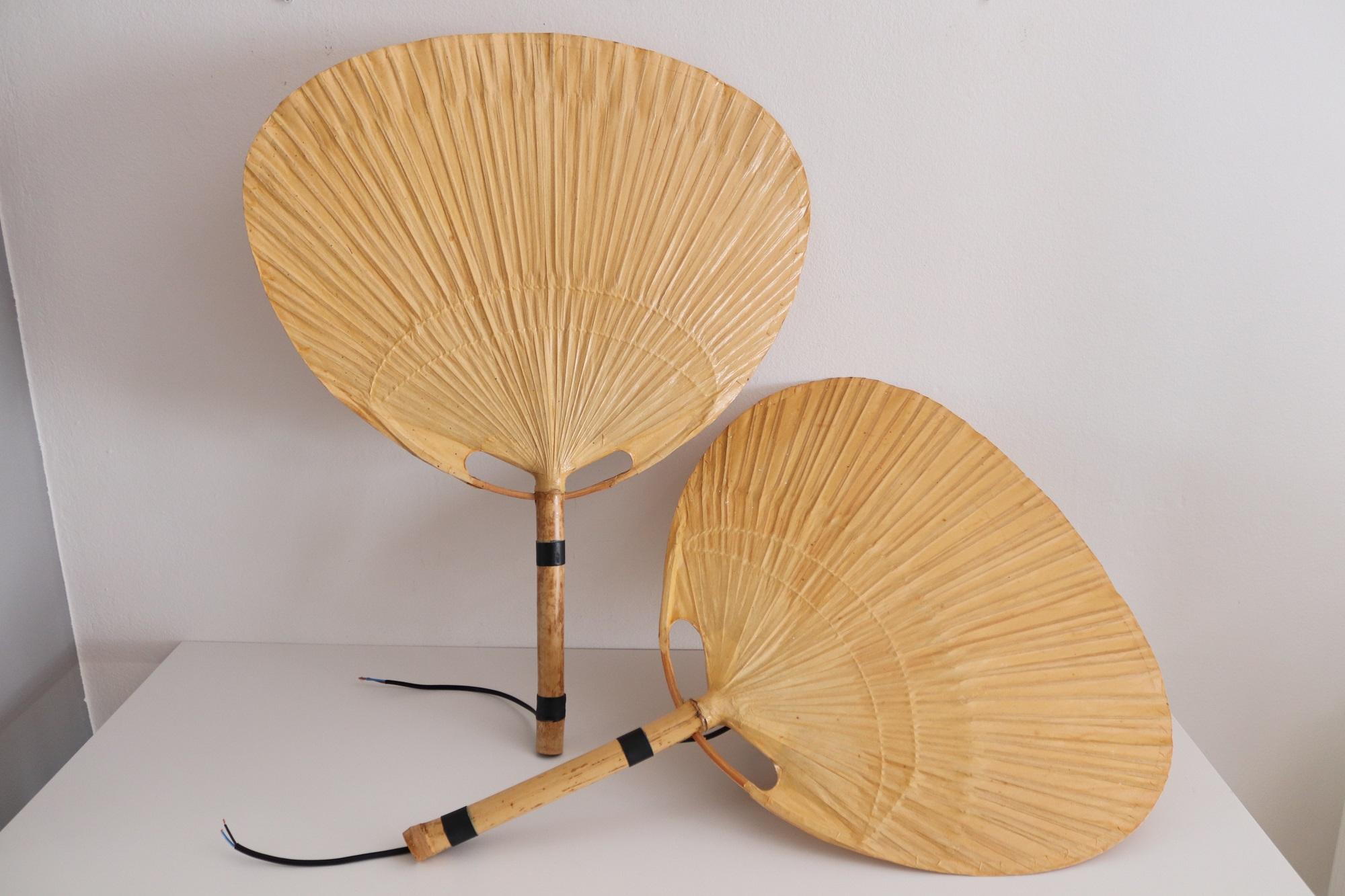 Two pieces of big vintage Uchiwa fan lamps with metal holder for wall hanging.
Designed from Ingo Maurer, Germany in 1973. One of two lights is equipped with original label 