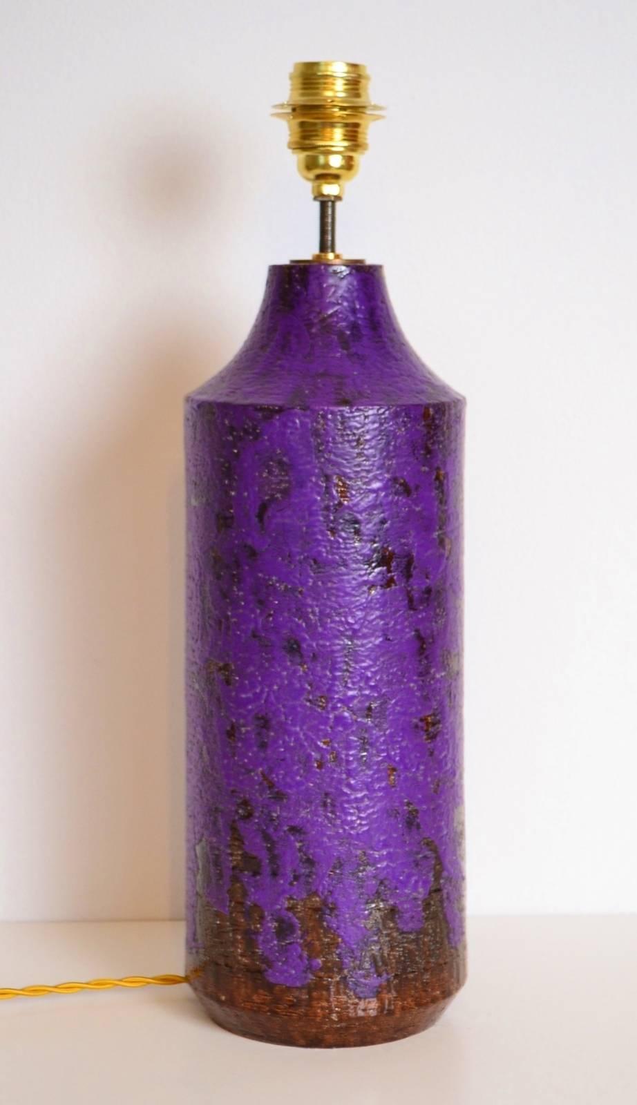 This beautiful lamp base made of heavy ceramic from Aldo Londi for Bitossi within the years 1967-1970.
The shiny purple color on brown underground is particularly beautiful and not seen that much on the vintage market.
The yellow fabric wire has