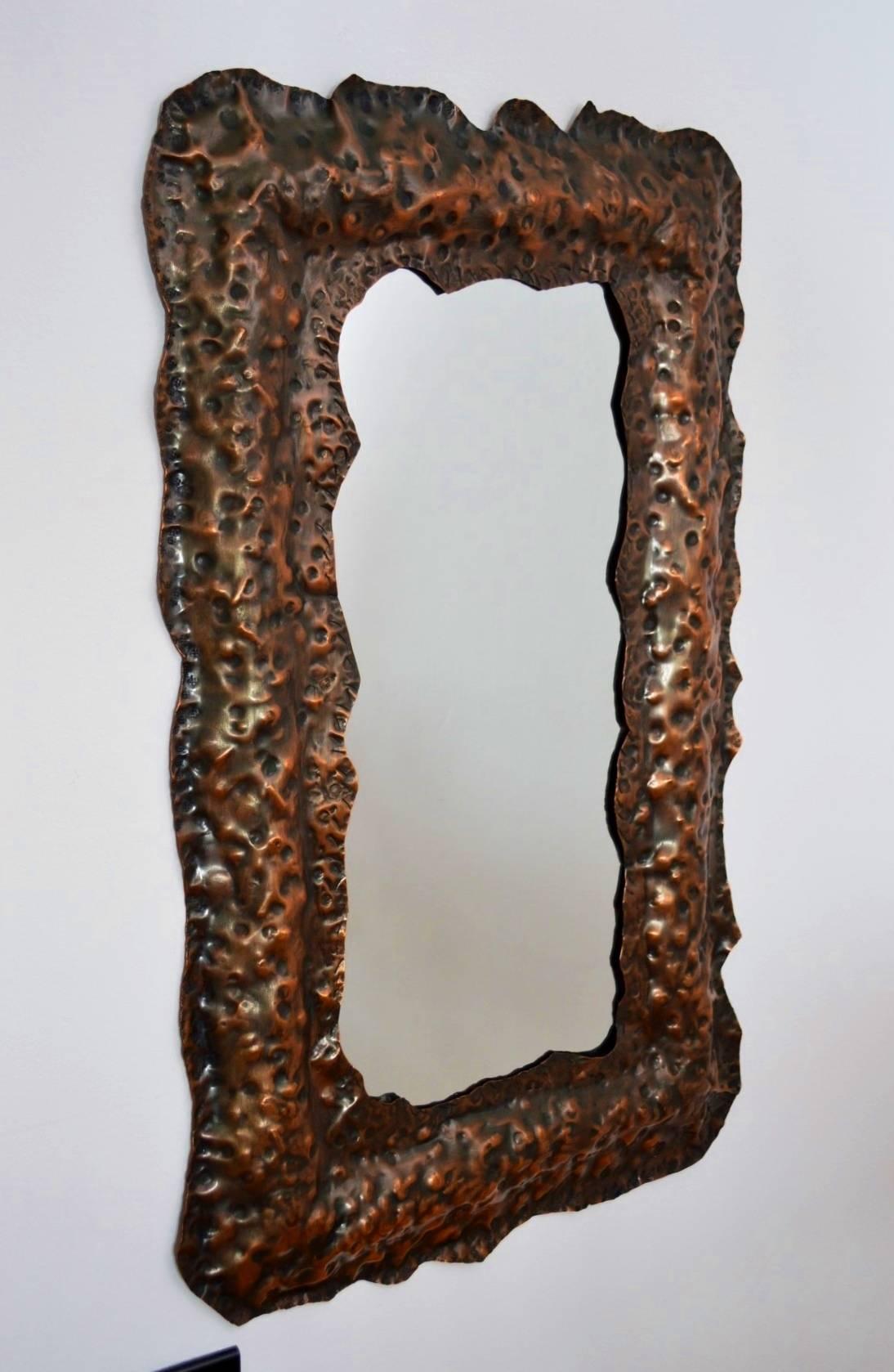 Beautiful and particular one-of-a-kind Brutalist style wall mirror or mirror sculpture, handmade of full copper.
Italy, circa 1970s.
By hand-hammered mirror frame made of one piece; at the backside one hook for wall hanging.
The glass is in best