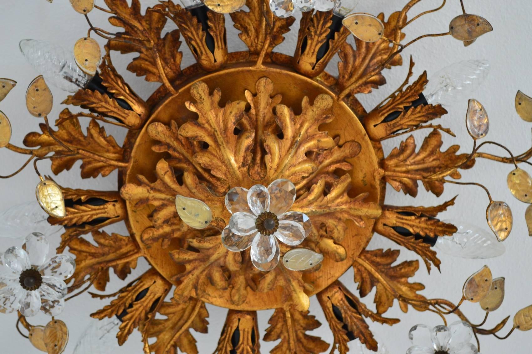 Beautiful rare and decorative floral flush mount lighting with gilt metal structure and leafs as well as leafs and flowers made of glass crystals.
All singular particulars are handmade and gilt (no spray)
The lamp is equipped with nine standard