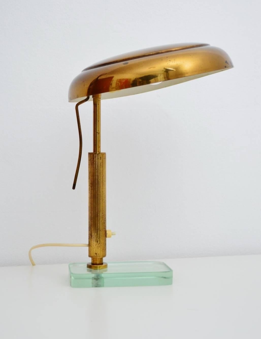 A very stylish and elegant desk or table lamp, made in the typical style of Fontana Arte : brass with glass foot of the Italian's, 1950s.
All brass parts are made of full brass (not brass sheet) and show a fantastic dark patina of the years with