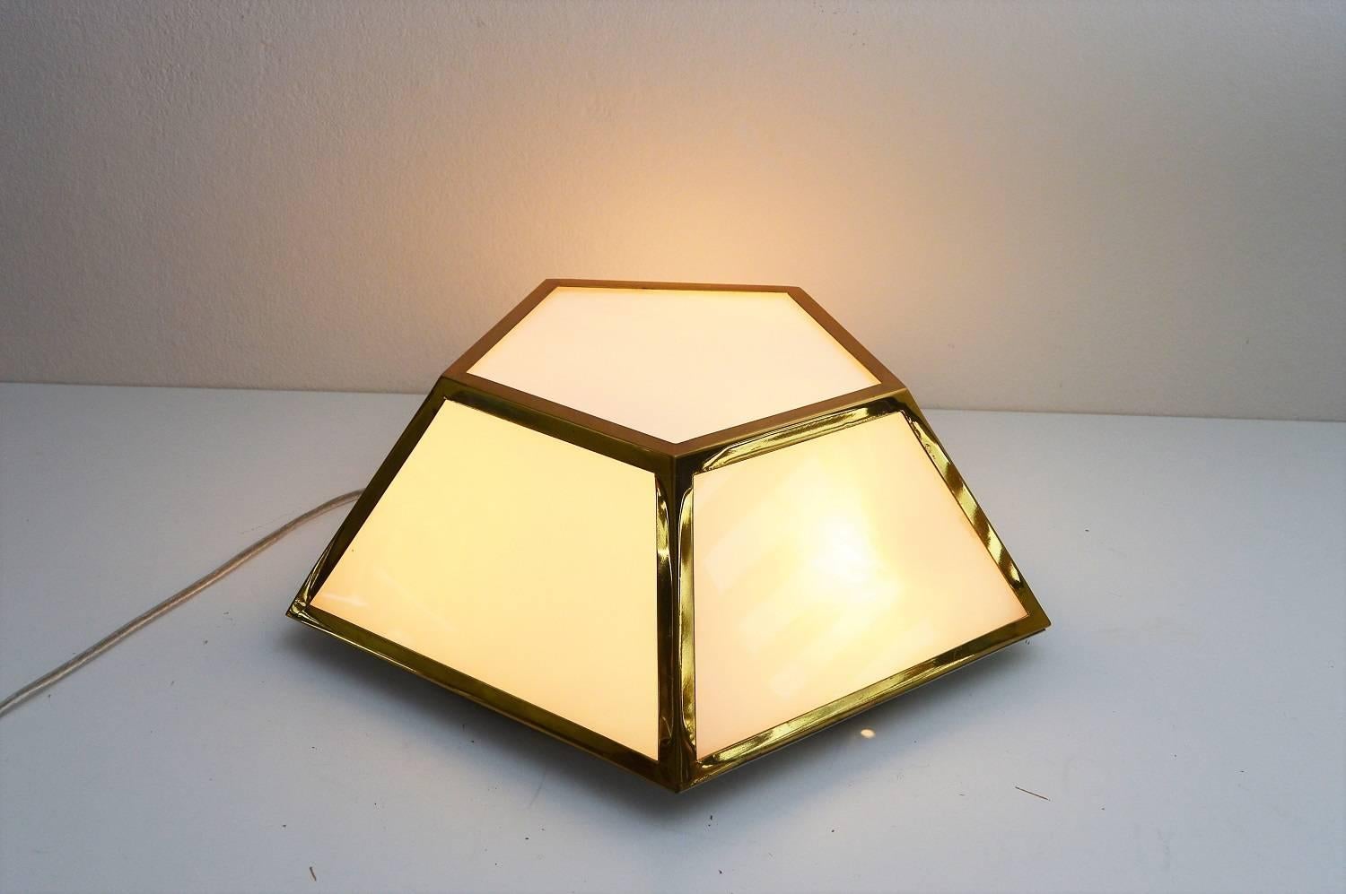 Beautiful elegant Art Deco Pentagon flush mount lighting or ceiling lamp, which could be used also as wall light.
Made of shiny brass frame with opaline white glasses.
Equipped for three small candelabra light bulbs.
Manufacturing attributed to