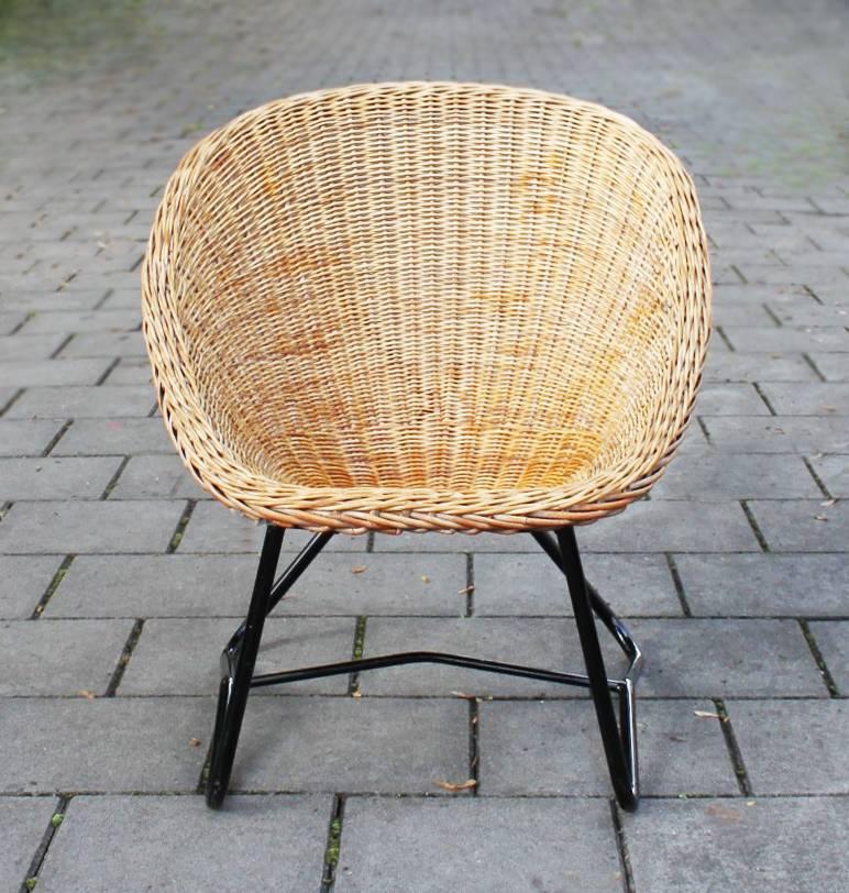 This woven bowl lounge chair has black enameled cross frame.