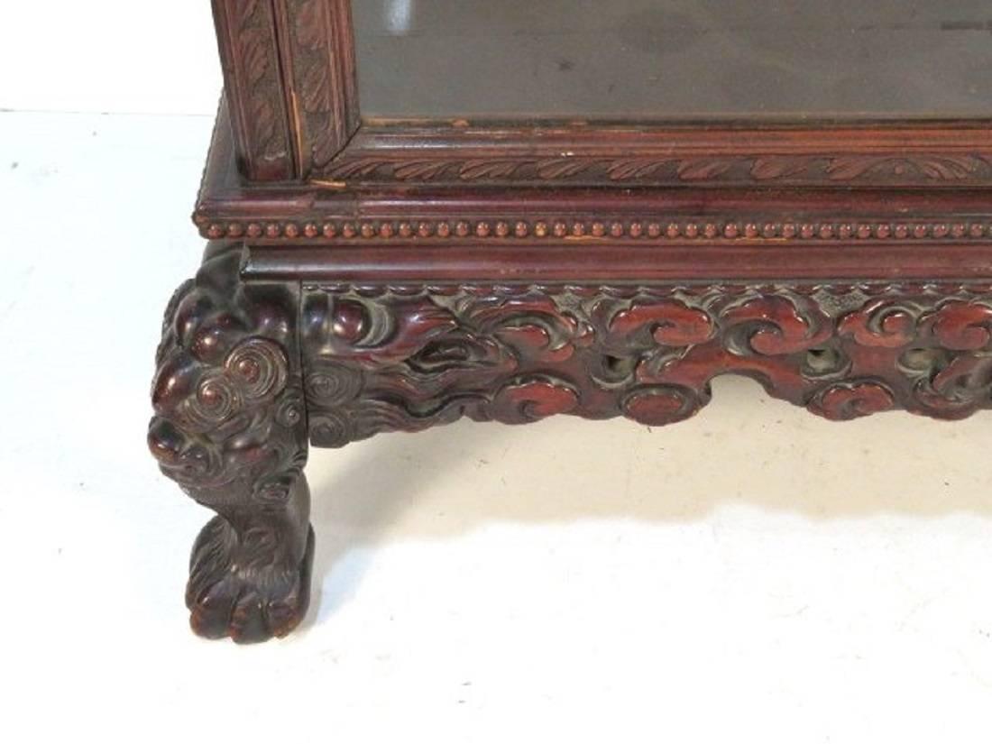 Cabinet is elaborately carved with shelves.