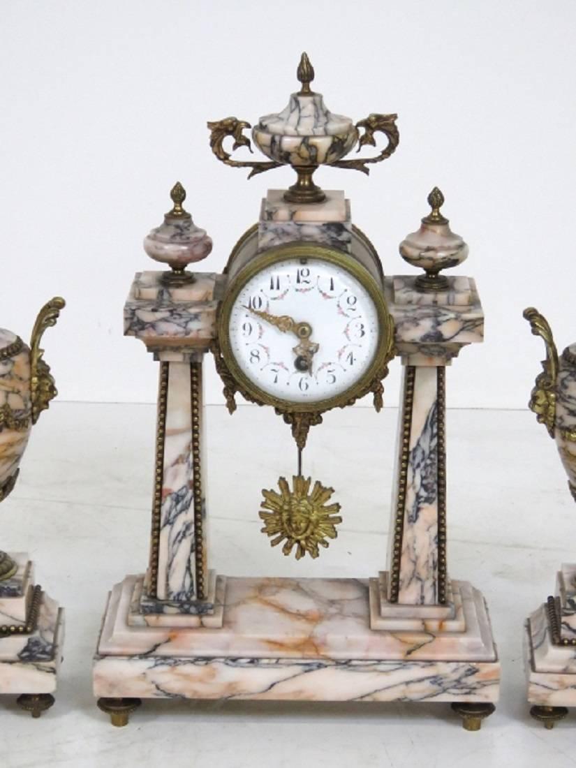 Clock set has pink and black marble with bronze mounts with lion head masks.