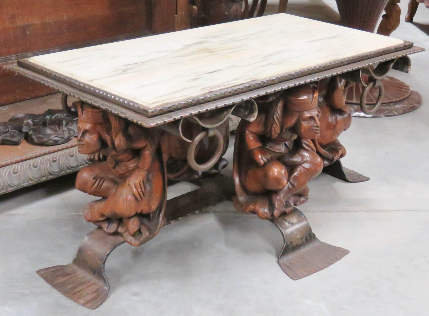 This is a great whimsical coffee table. The frame is mar of solid cast bronze and ornamental iron legs with carved court Jesters supporting the marble top. This is a unique and certainly one-of-a-kind form of table. 
