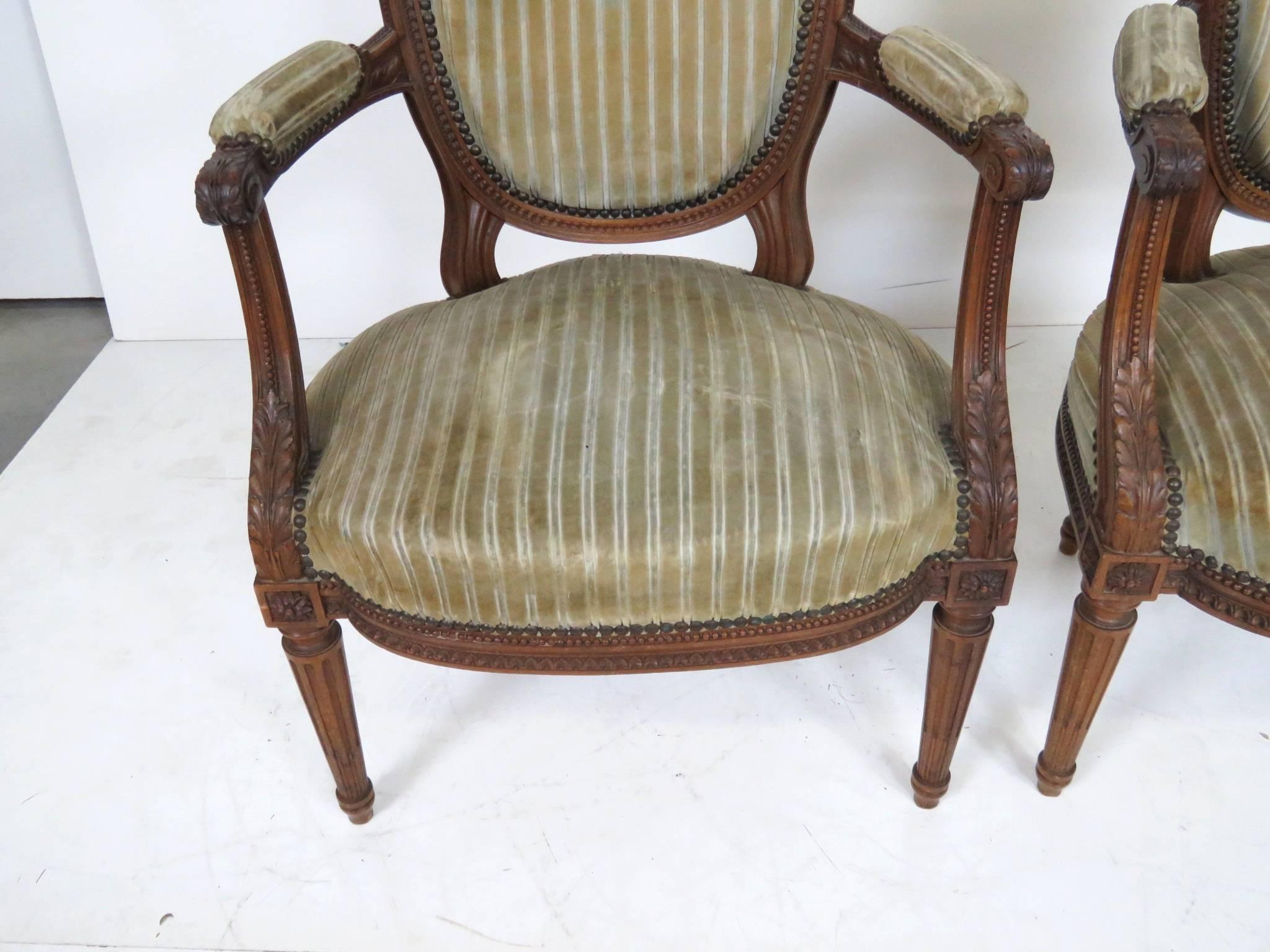 Finely carved walnut frames. Striped upholstery.