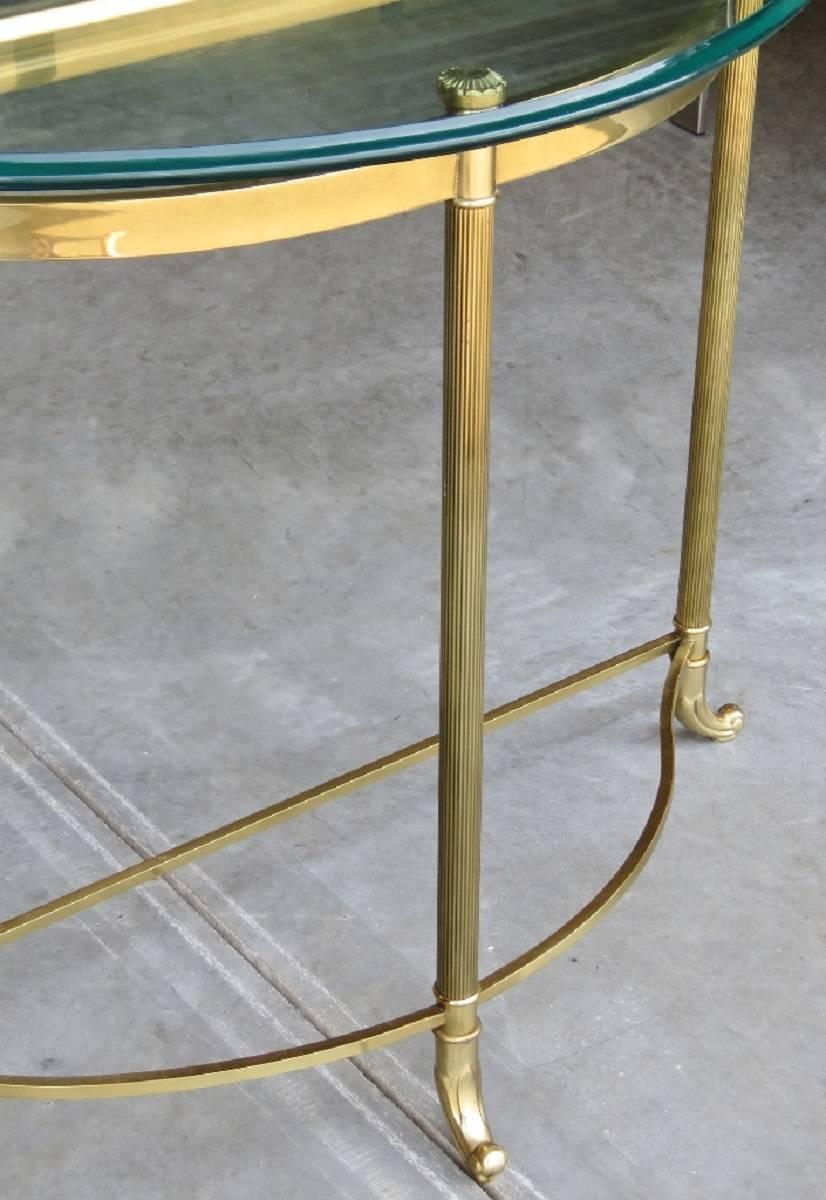 Demilune console table, brass base with glass top.