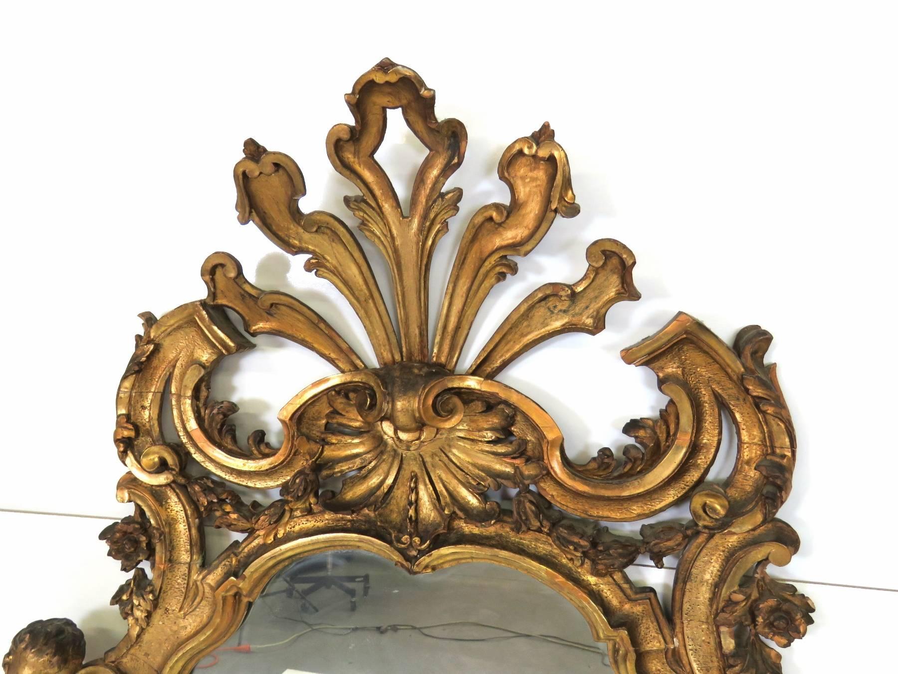 Carved giltwood with cherub heads.