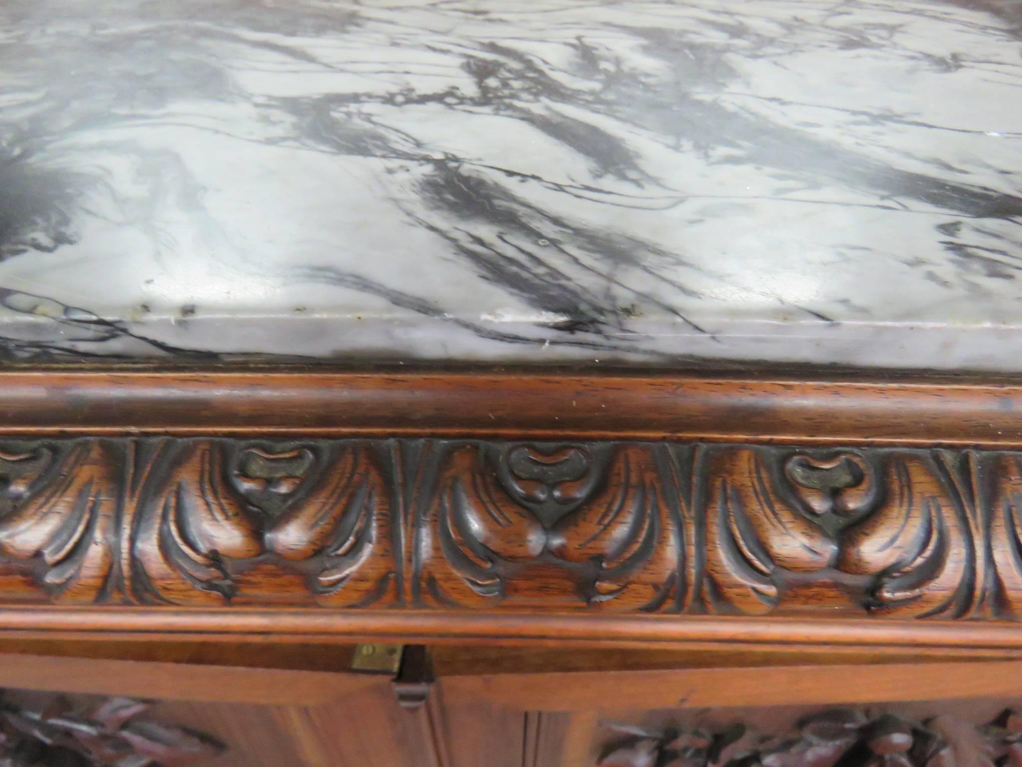 Carved griffins, fruit, gamebirds and fish. Mirrored back. Marble top.