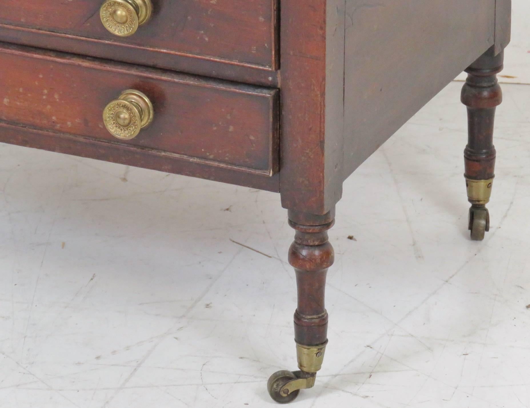 Mahogany with slots for magazines and newspapers and drawers for storage. Brass hardware and rolling feet.