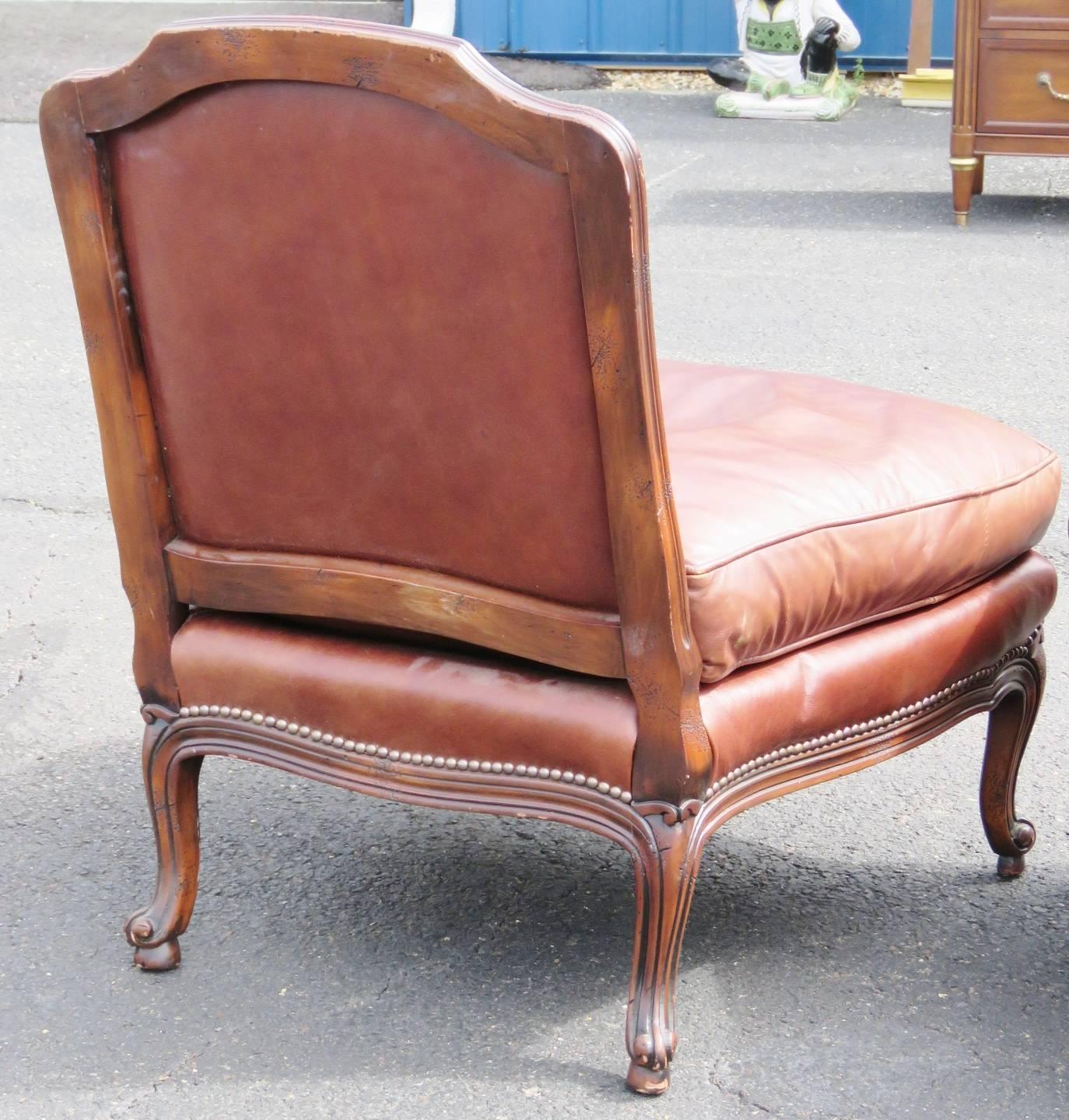 Brown leather upholstery with tacked edges. Carved walnut frame.