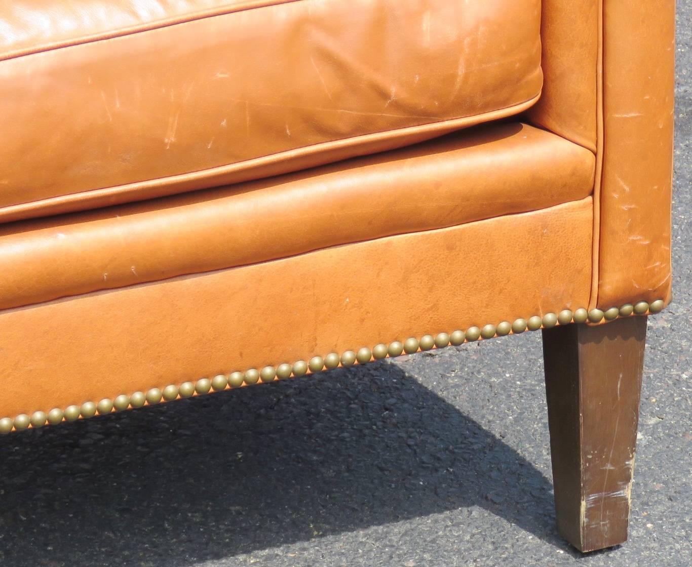 Brown leather wood legs. Tacked bottom. Bernhardt label.
